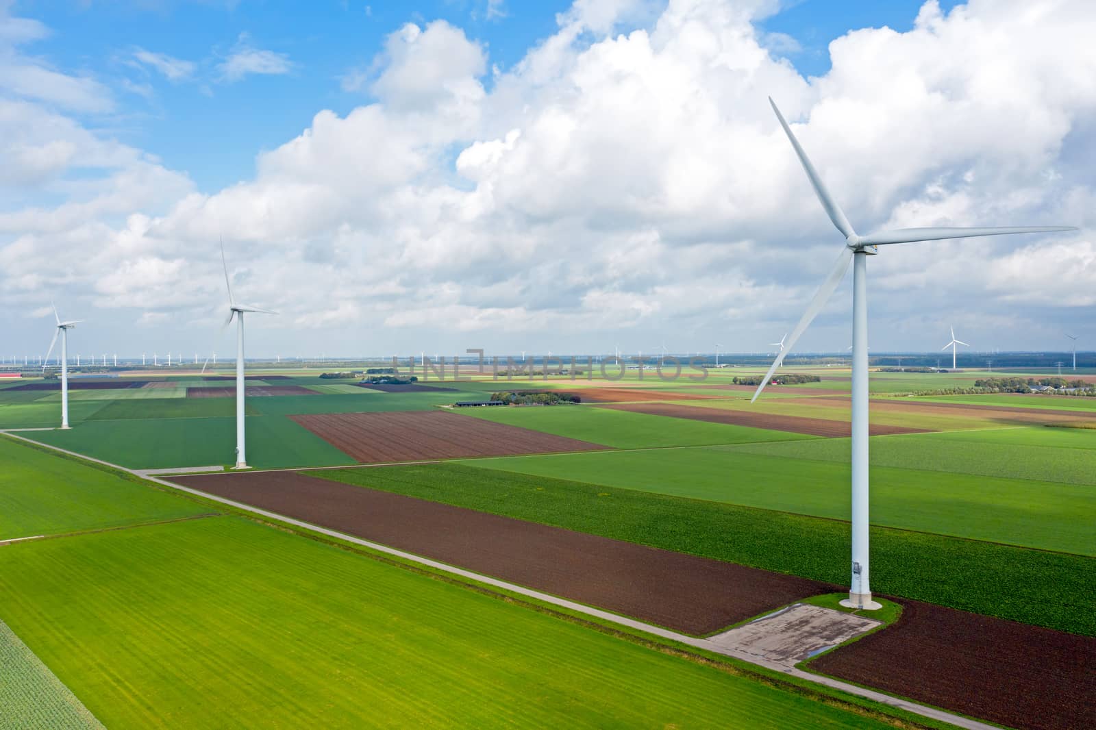 Aerial from a dutch landscape with windturbines, meadows and beautiful skies
