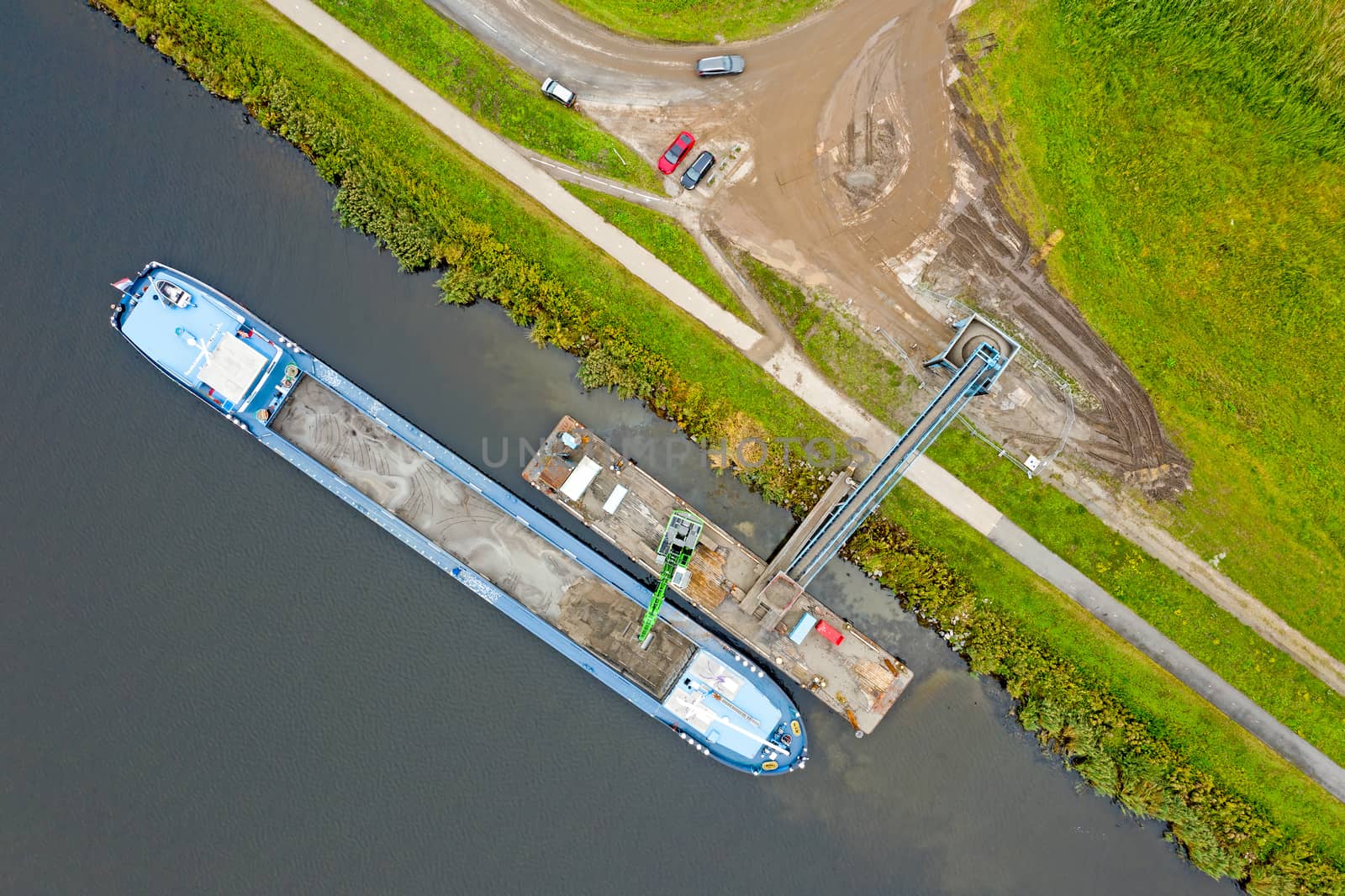 Aerial top shot from freighter unloading sand in the countryside from the Netherlands