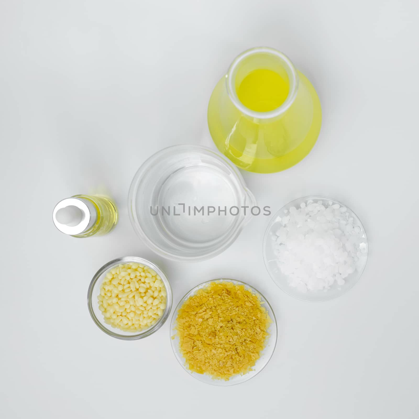 Cosmetic chemicals ingredient on white laboratory table. Carnauba Wax Flakes SP-200, Candelilla Wax SP-75, Microcrystalline wax, Nickle chloride liquid, alcohol