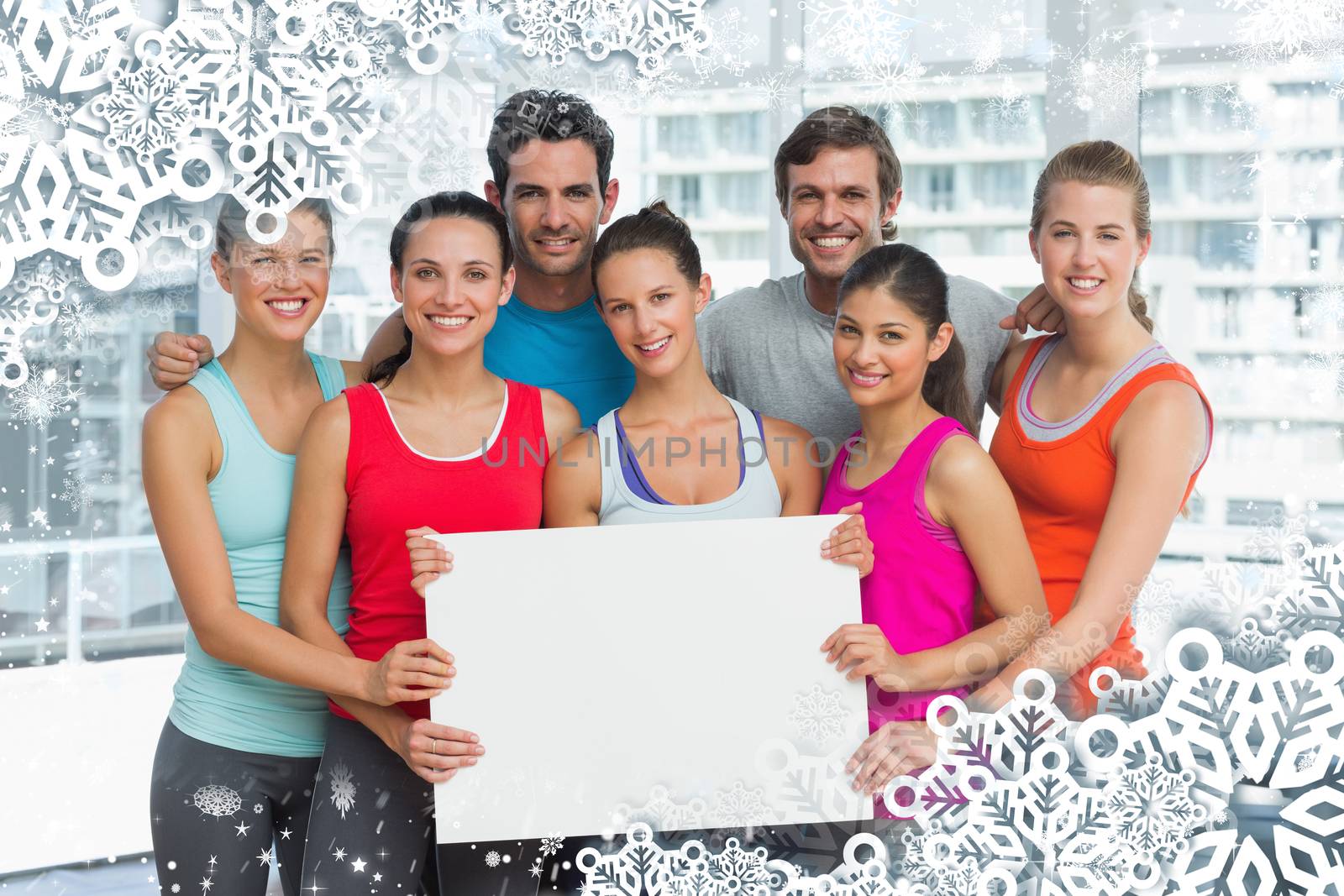 Fit smiling people holding blank board against snow