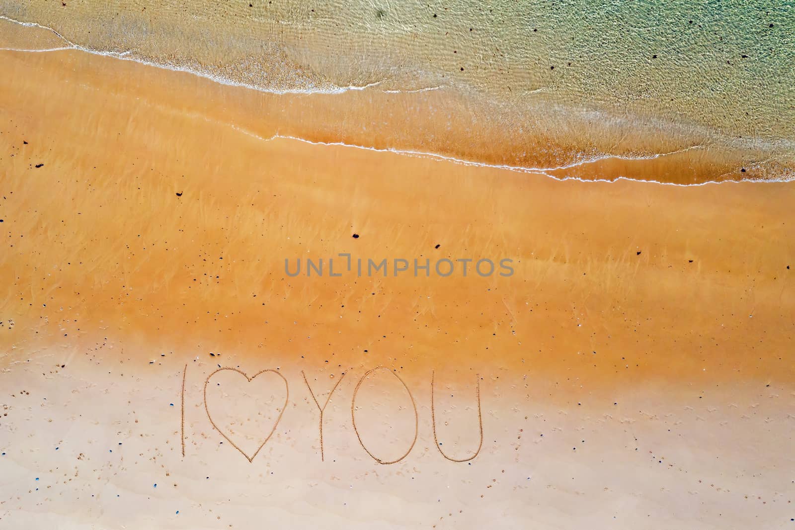 Aerial top shot from ocean waves and handwritten I love you at t by devy