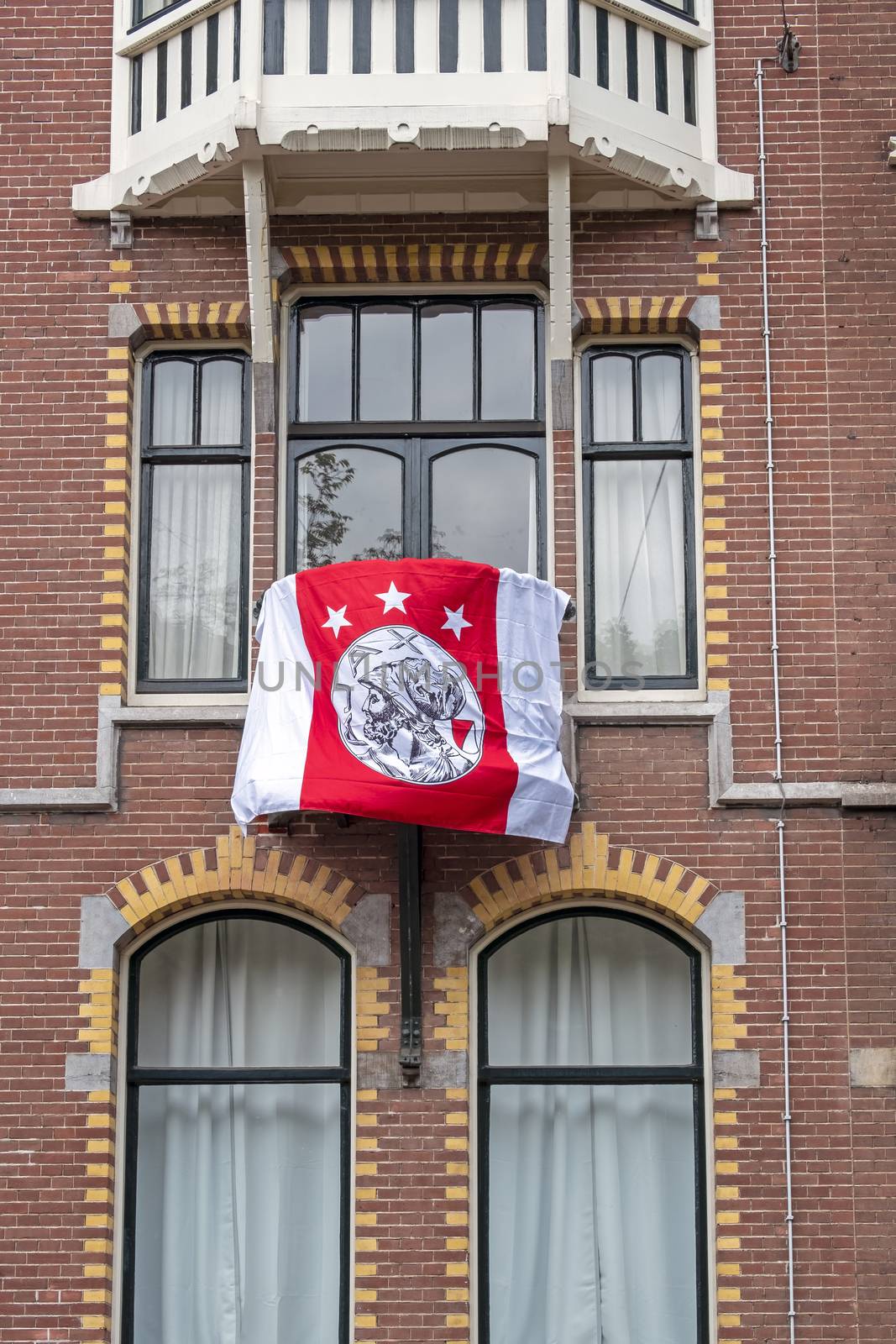 Amsterdam, Netherlands - May 16, 2019: Dutch facade with the Ajax flag honoring the national championship from Ajax in Amsterdam the Netherlands
