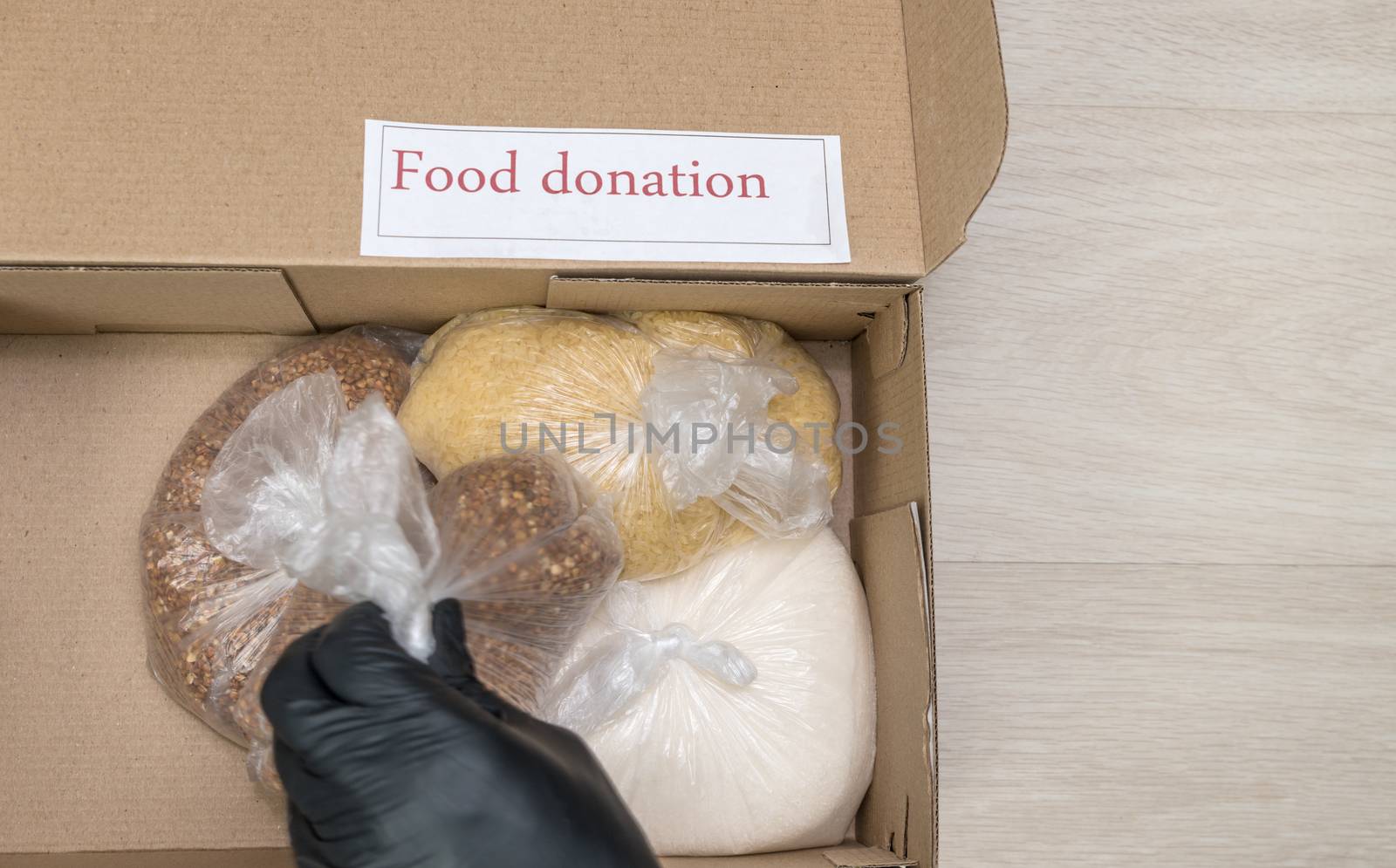 hand puts in box with long term food supplies by FoXovsky
