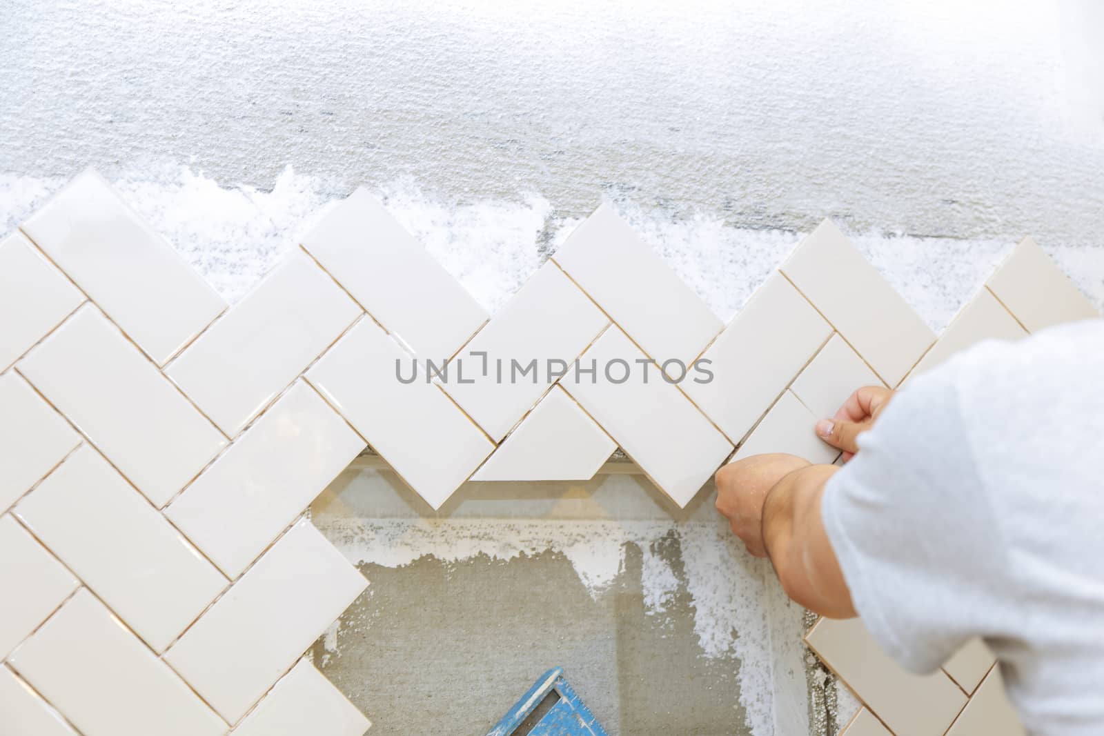 Troweling mortar into the hands of laying the tiles the ceramic tile