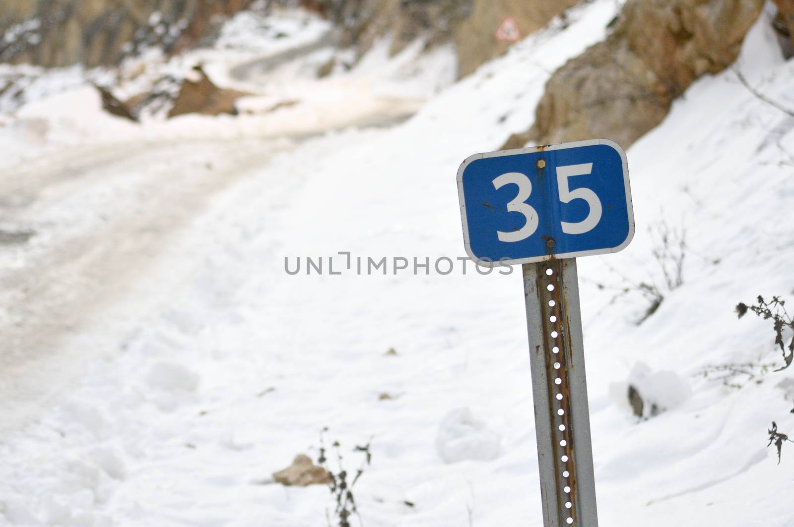 Road signs. The roads in the snow-capped mountains. by moviephoto