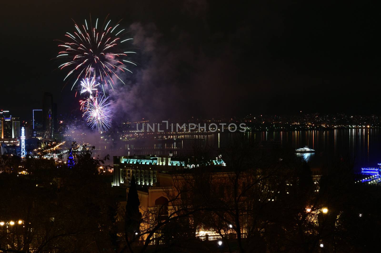Colorful and various salutes and fireworks in the night city of Baku over the Caspian Sea.