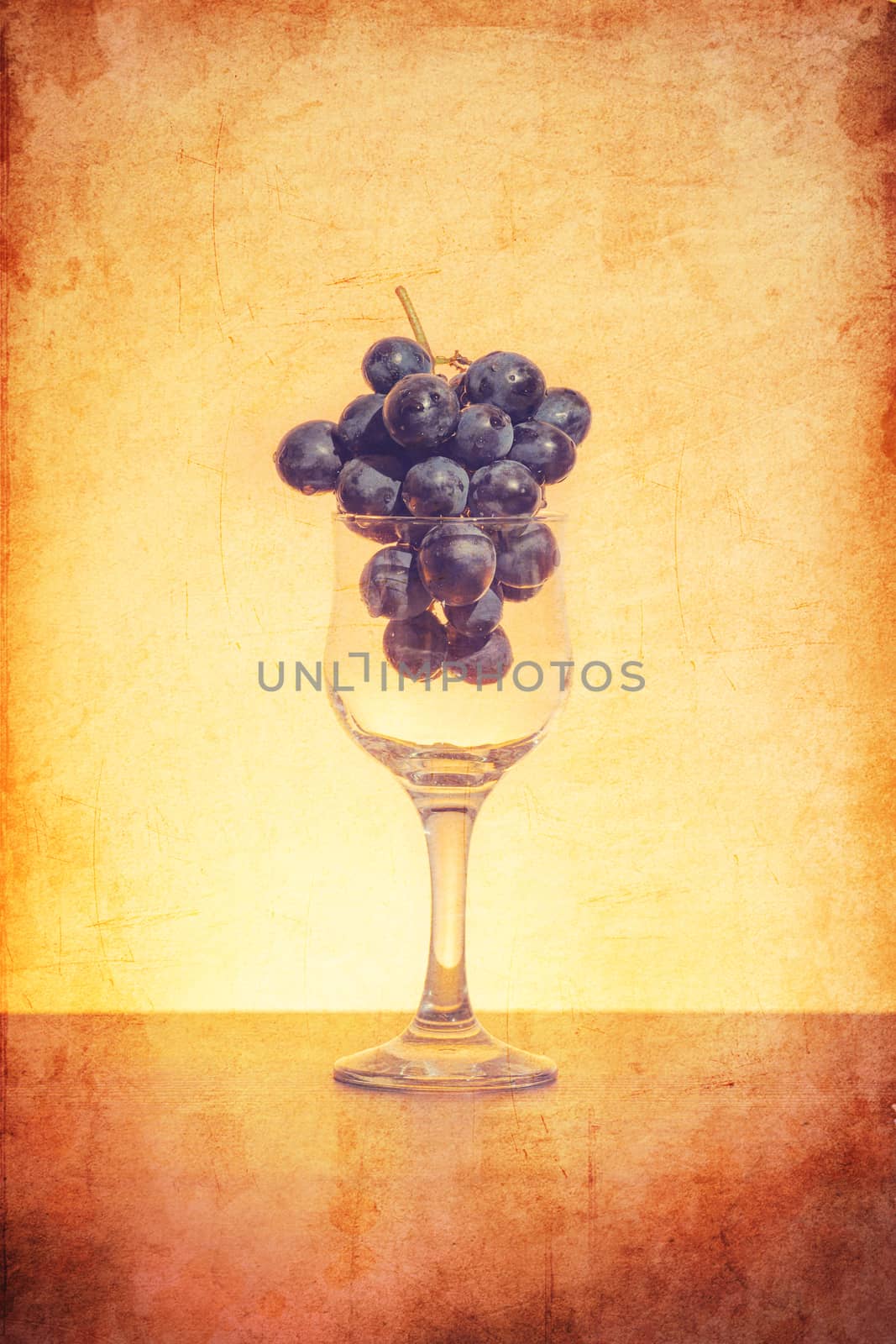 Conceptual idea of grapes in the wine glass as raw material instead of  final product using retro filter