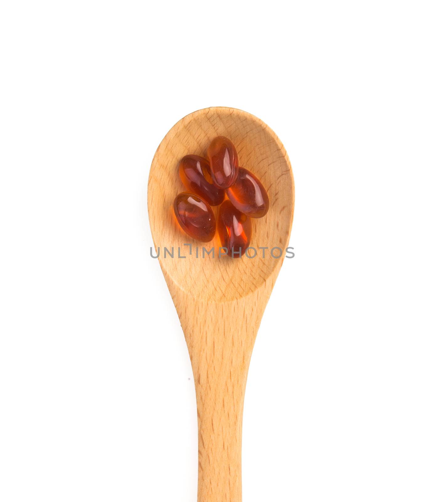 pills in wooden spoon isolated on white background