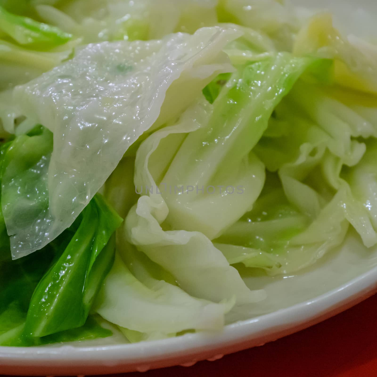 The close up of delicious stir fried cabbage on white plate at Taiwanese restaurant.