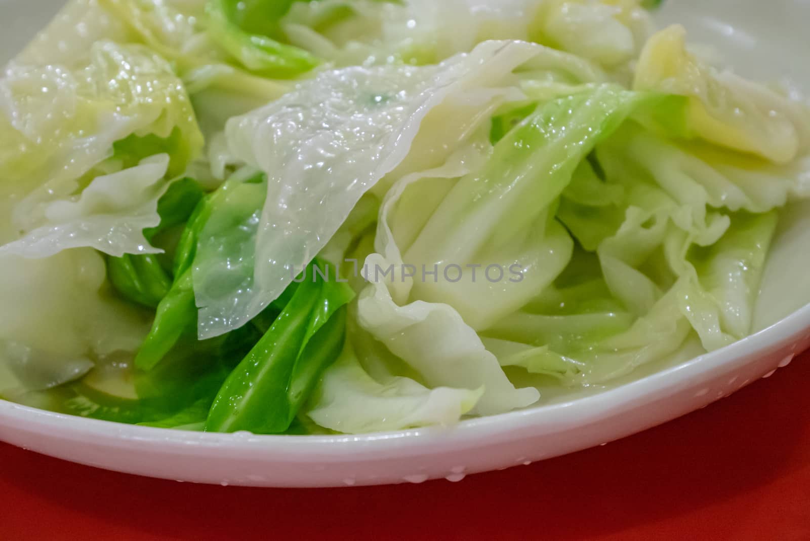 The close up of delicious stir fried cabbage on white plate at Taiwanese restaurant.