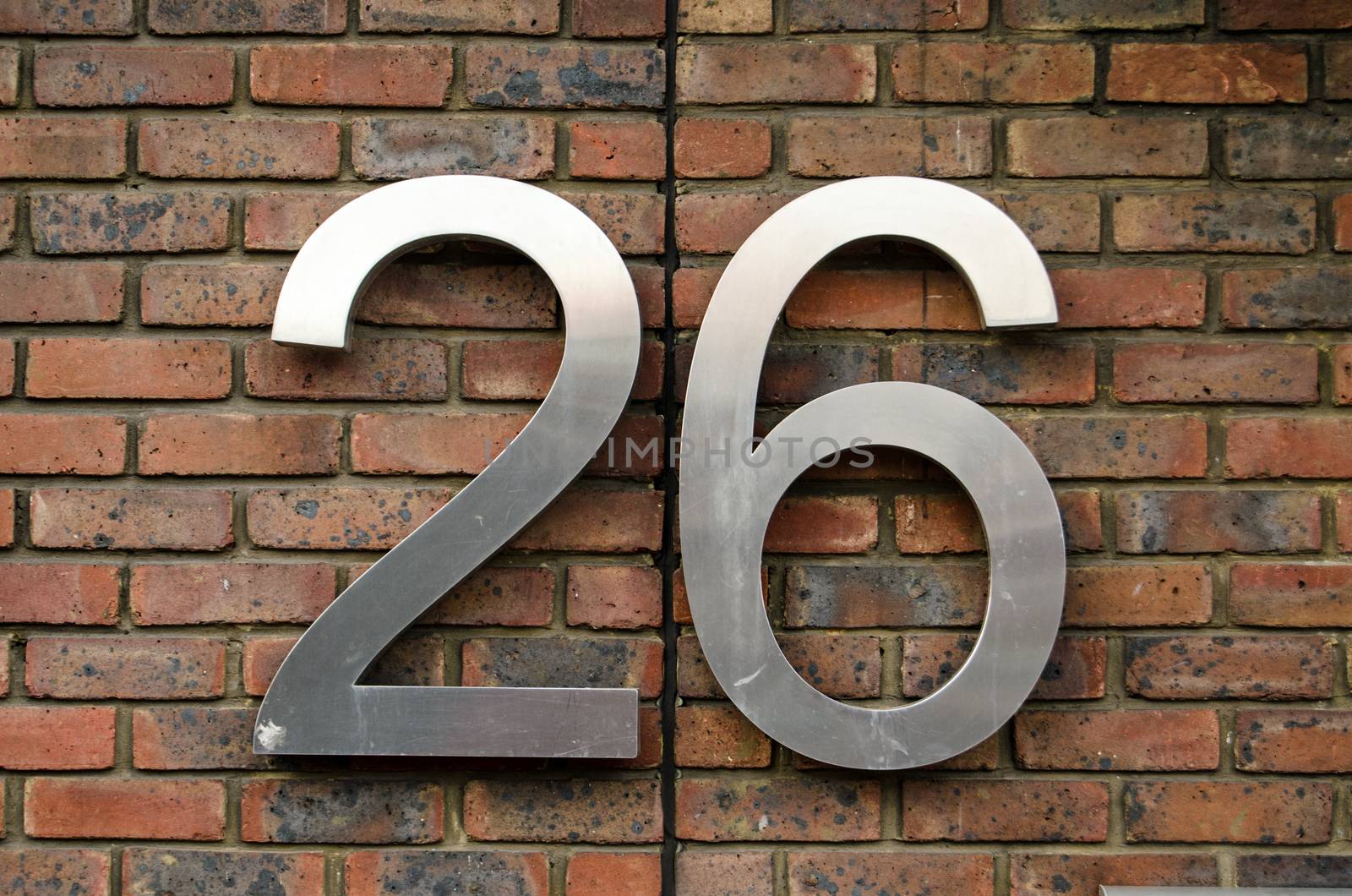 Figures for the number twenty six attached to the outside wall of an office block.