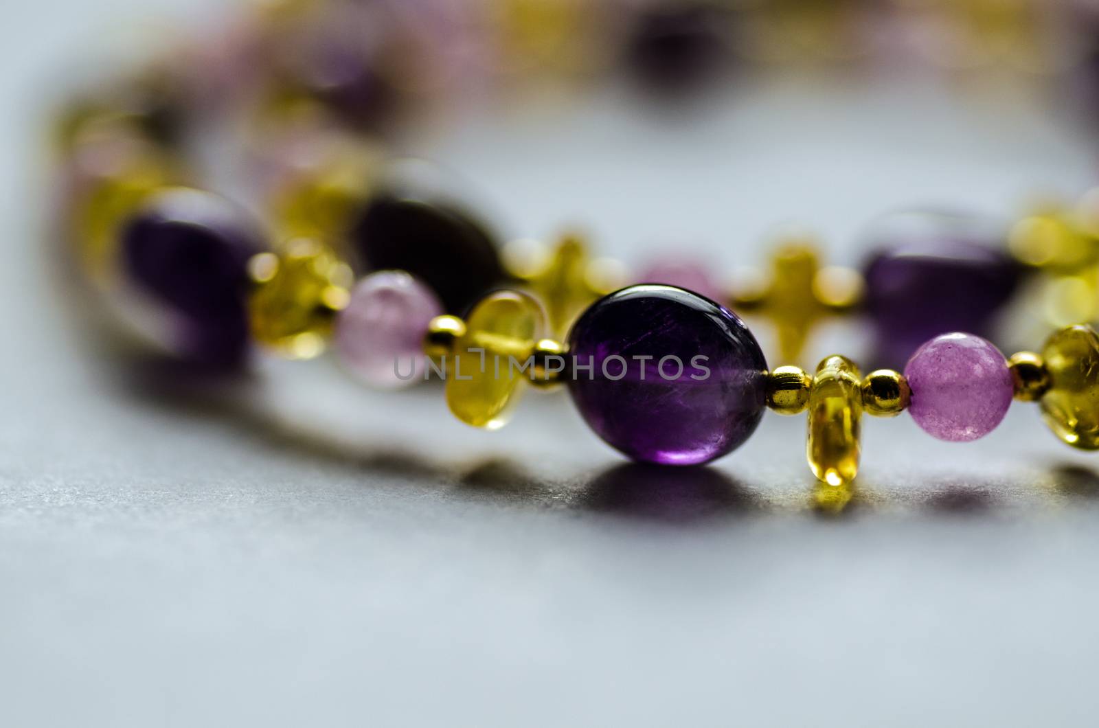 Necklace hand made from amethyst, quartz and amber beads interspersed with gold plated beads.  