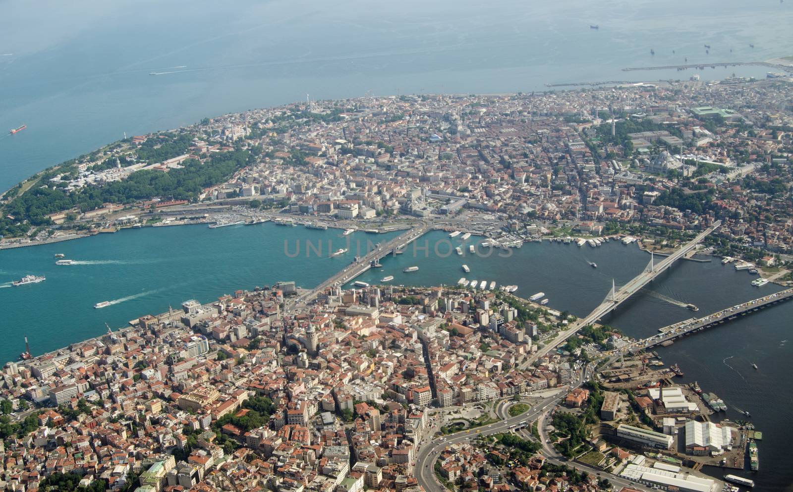 Aerial view looking south across Istanbul across the Golden Horn waterway towards the old city and the Marmara Sea beyond.  Crossing the Golden Horn are the Galata, Ataturk and Halic bridges.