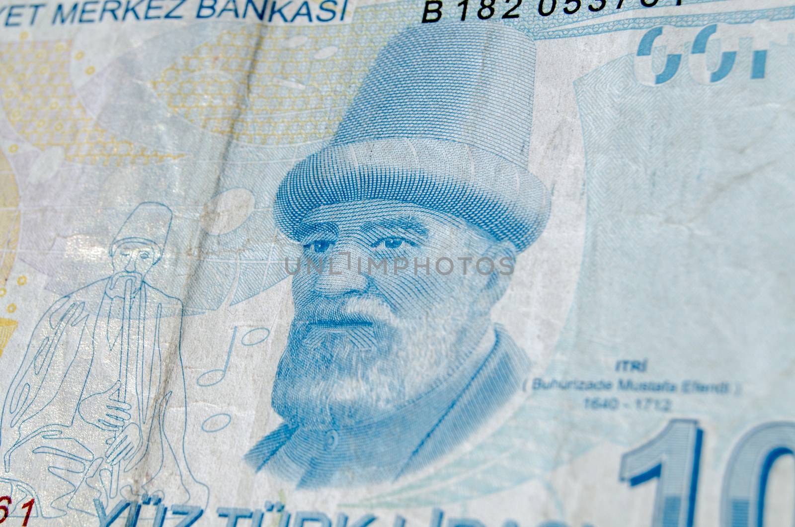 A used 100 Turkish Lira banknote showing the composer Buhurizade Mustafa Itri.  Banknote photographed at an angle.