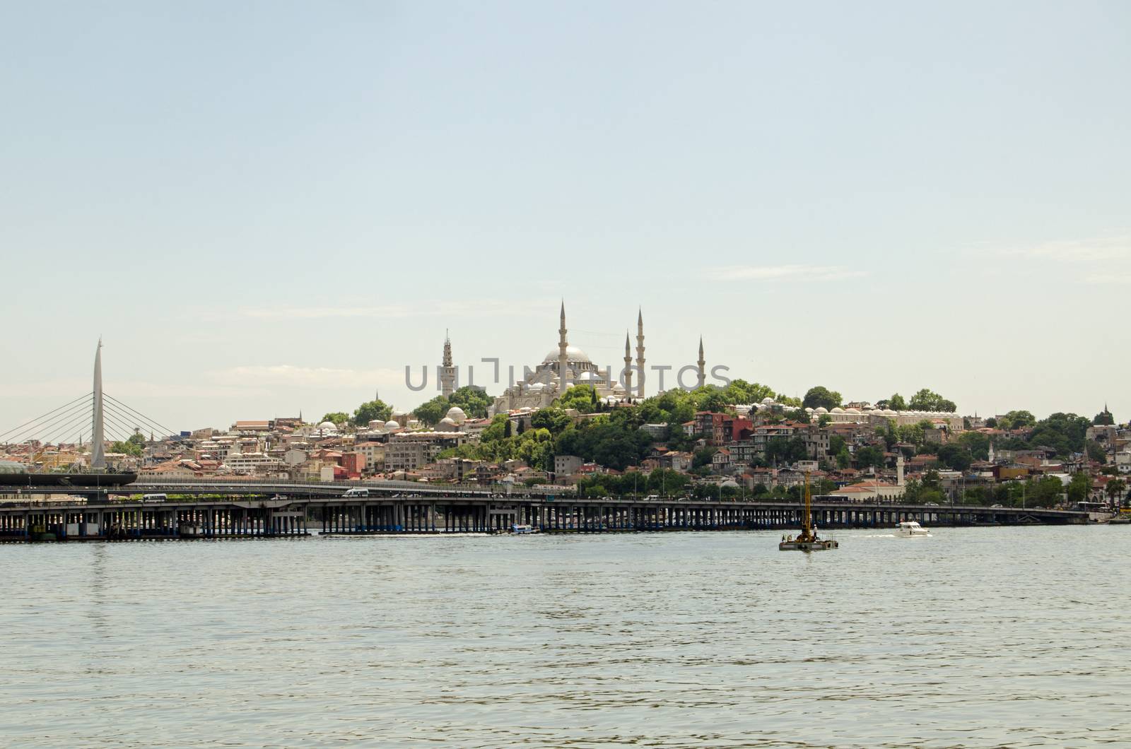 The magnificent Suleymaniye Mosque overlooking the Golden Horn with the new Halic Metro bridge in the foreground on a sunny Sunday afternoon in Istanbul, Turkey.