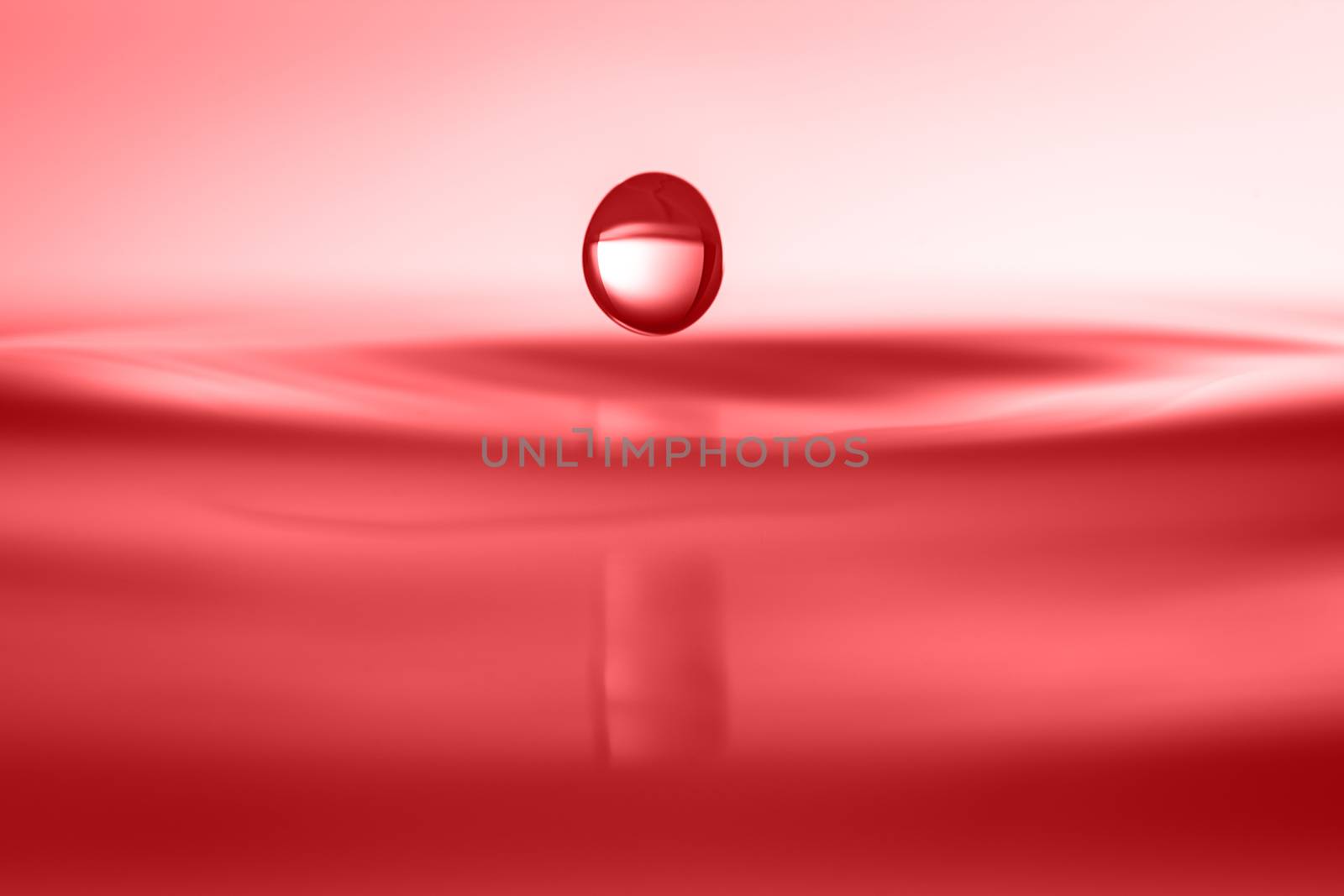 A water drop falling down onto a water surface