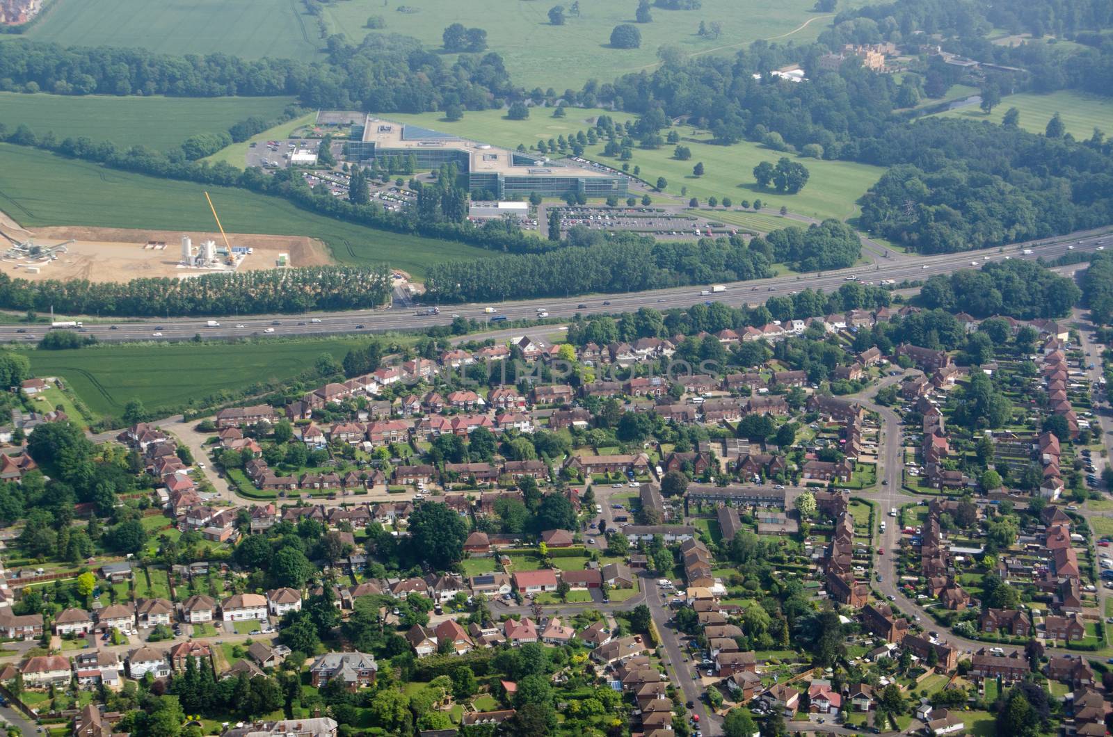 Aerial view across the Berkshire village of Datchet, across the M4 motorway towards Ditton Park and the headquarters of CA Technologies.  Sunny morning, Summer.  