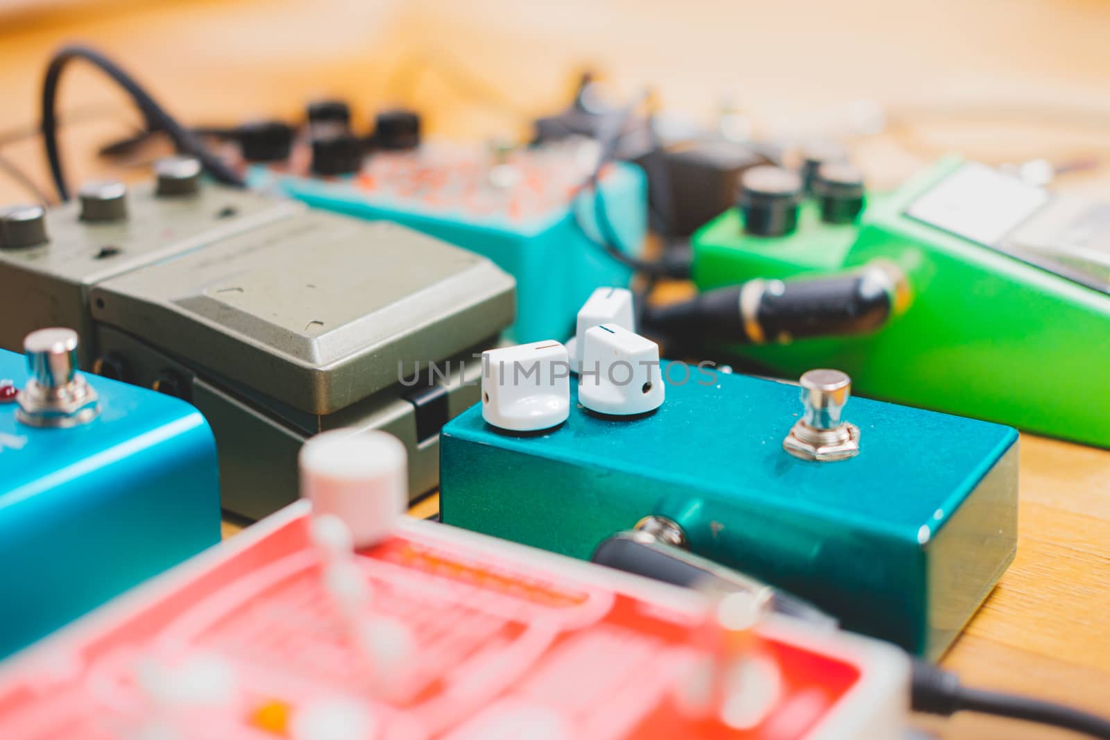 Guitar pedalboard on the floor of a recording studio. by photoboyko