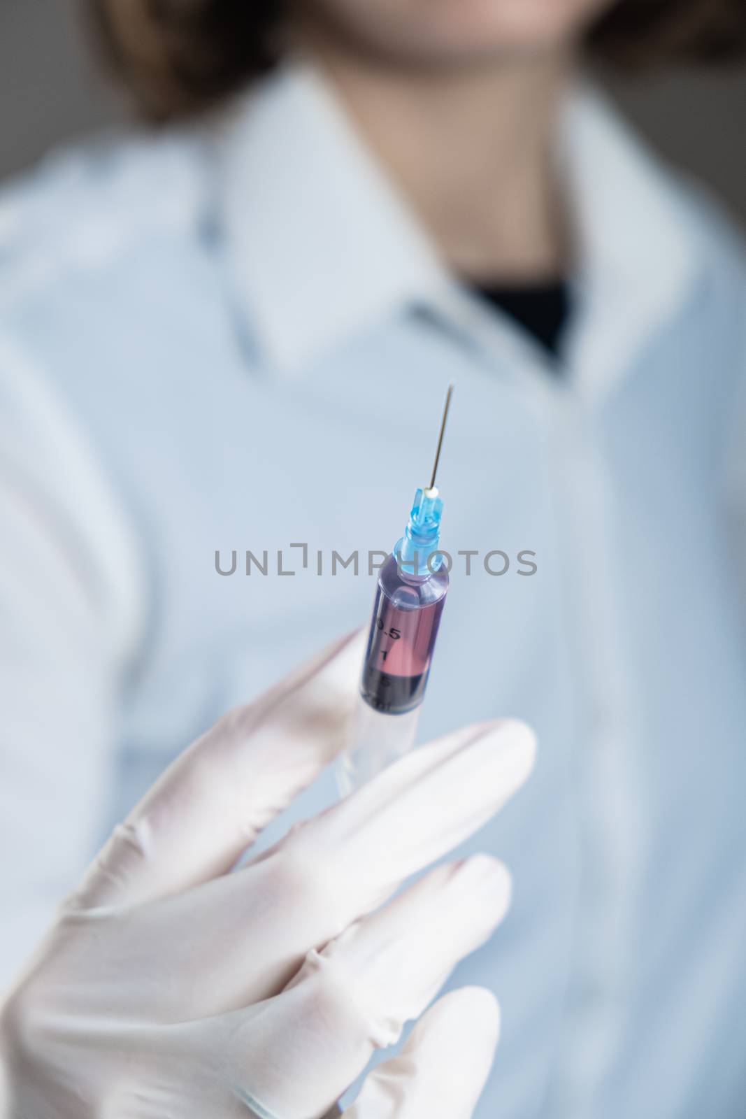 Injection ready for application in doctor's hand. Hand in glove holding a syringe with intravenous injection, concept of medical treatment