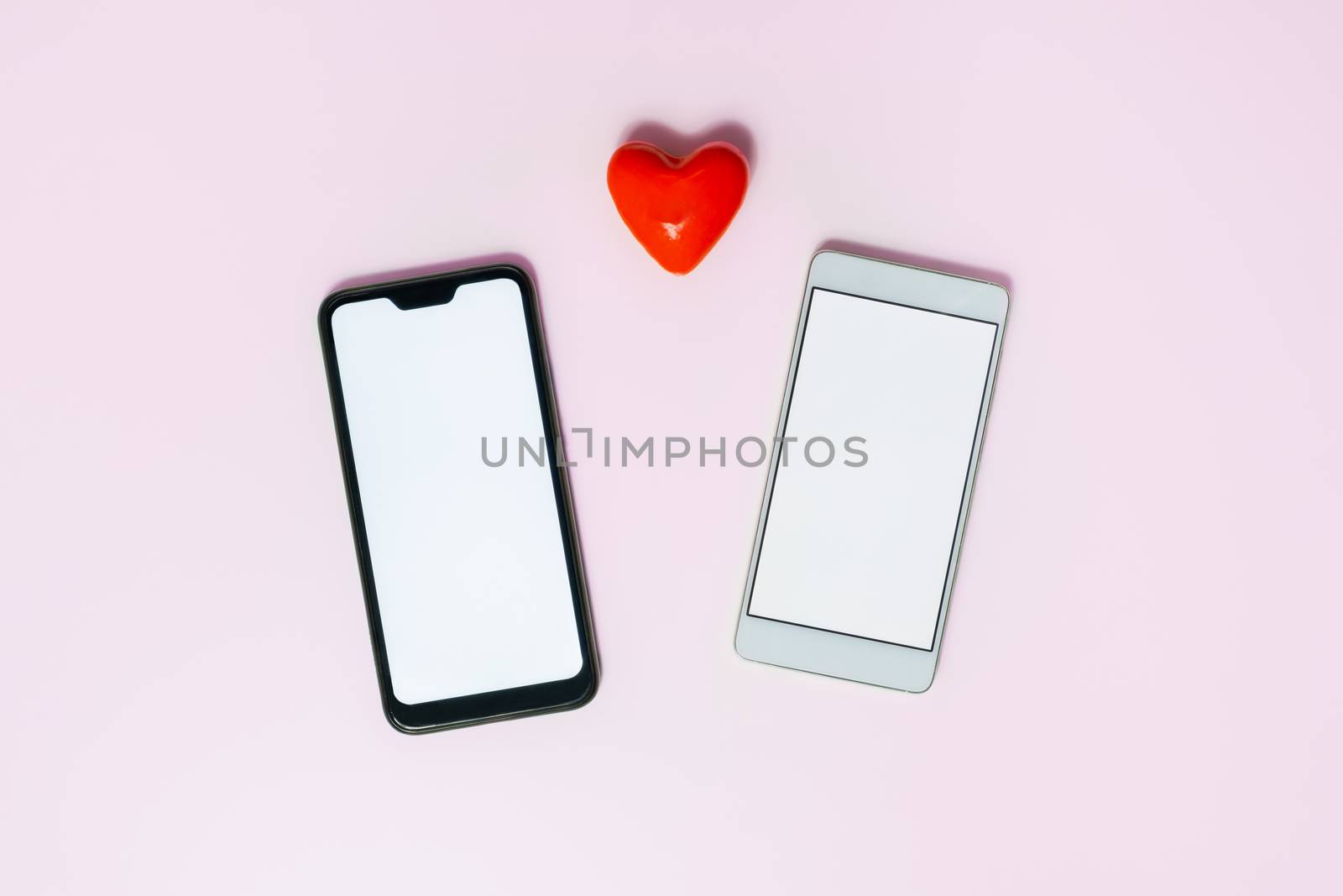 Two telephones in pink backdrop with a heart by photoboyko