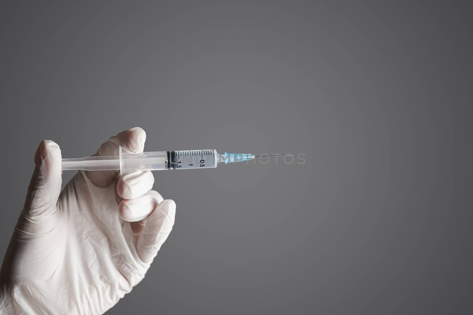Injection ready for application in doctor's hand. Hand in glove holding a syringe with intravenous injection, concept of medical treatment or vaccination