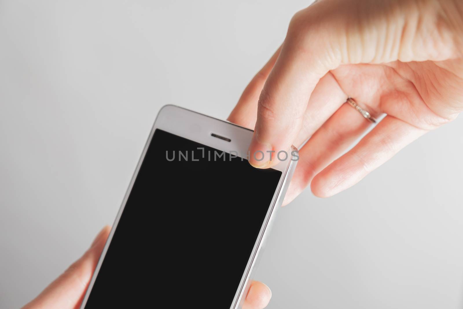 Thumb covers up the front facing camera of a smartphone. Concept of privacy, online security of a firewall