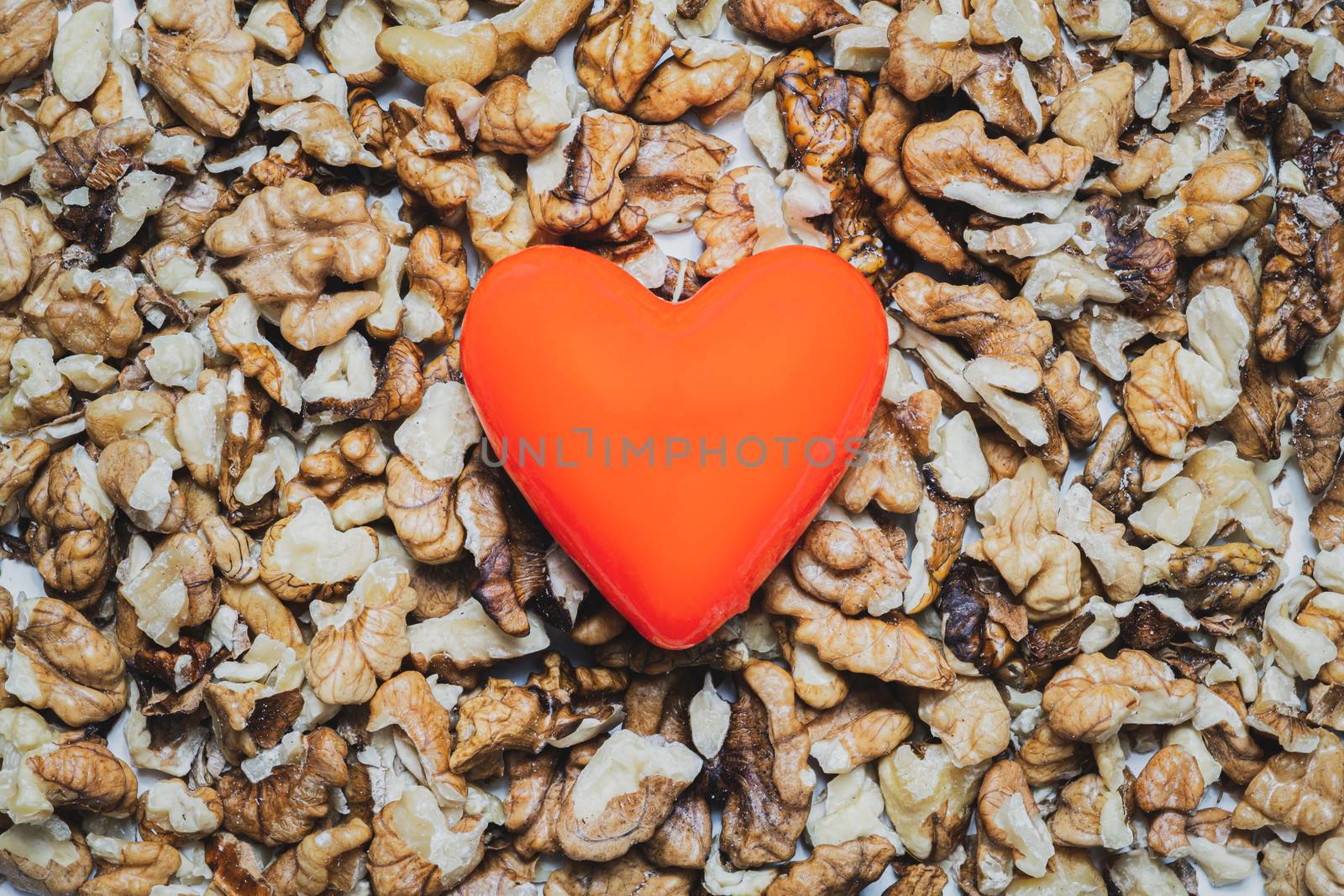 Heart shape on a heap of walnuts. Food for the heart's health, healthy eating concept.