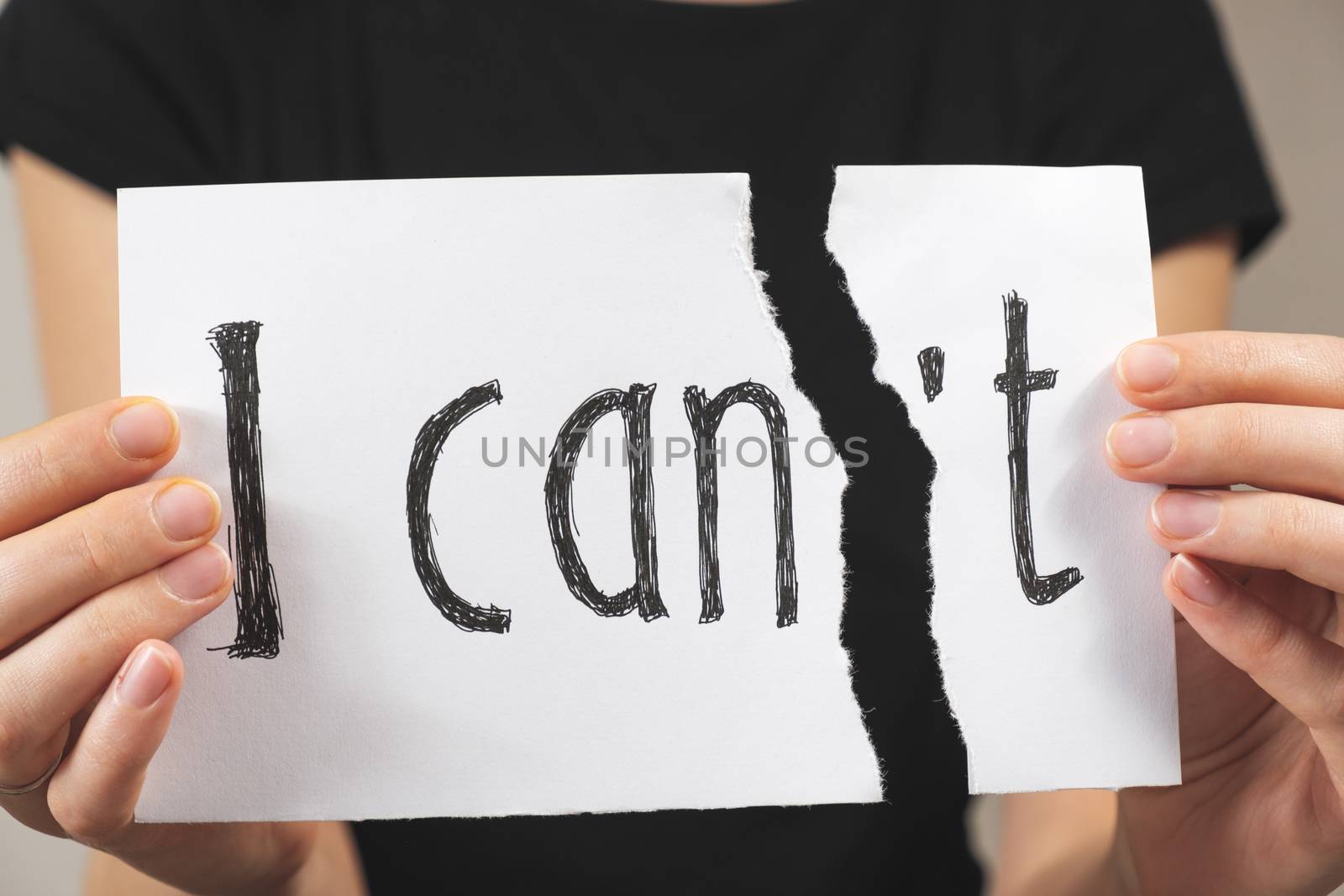 Hands tearing out negation of the "i can not" sign. Motivational concept of believing in yourself and overriding problems and emotional difficulties