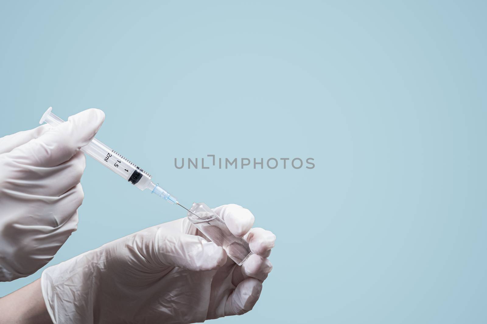 Hands in gloves preparing a medical injection shot, copy space. by photoboyko