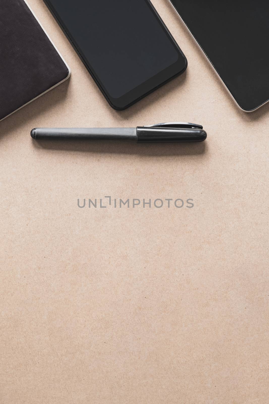 Business flat lay on brown paper background. Smartphone, tablet  by photoboyko