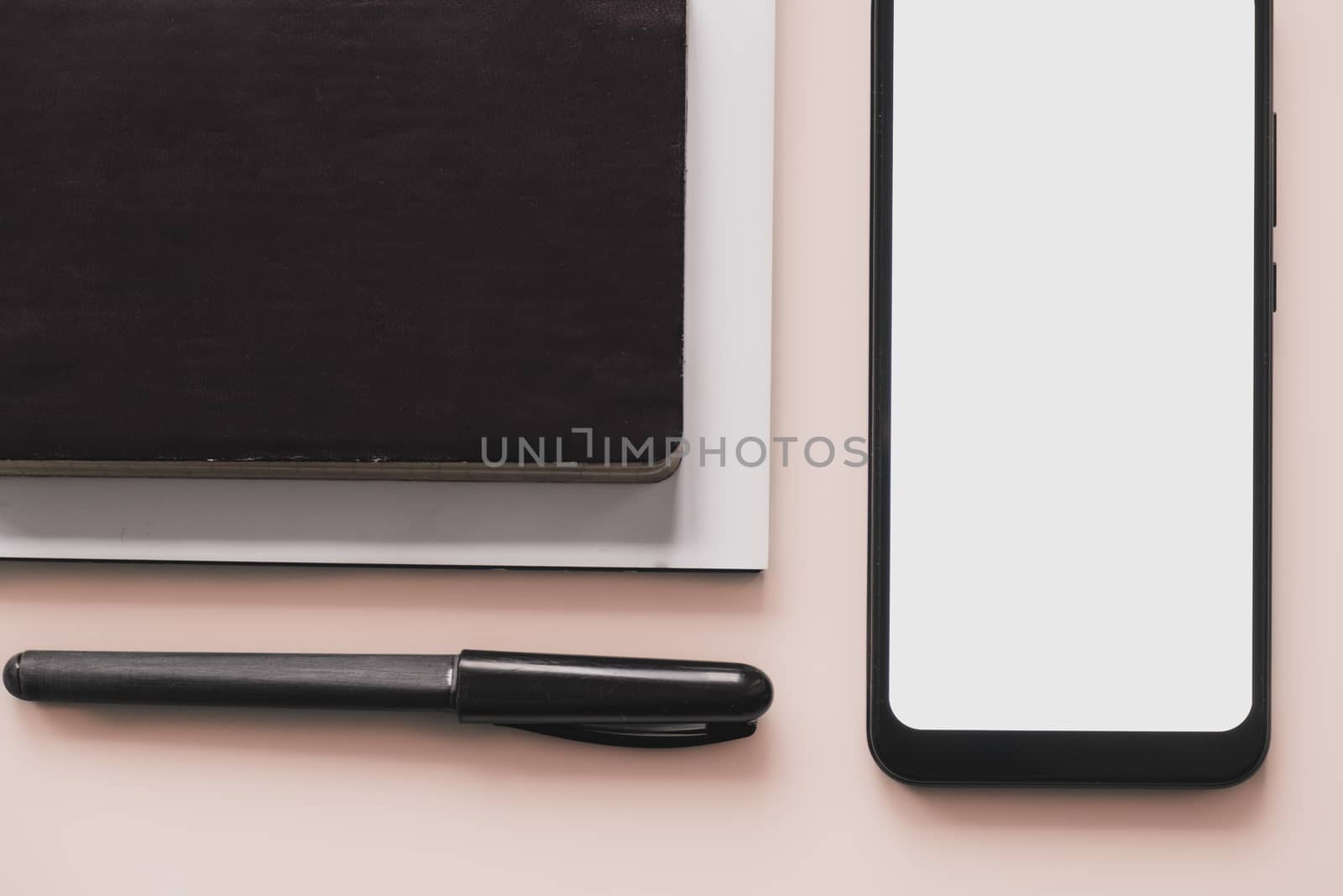 Business flat lay on pastel background. Smartphone, writing pen and notebook organizer on minimalistic background