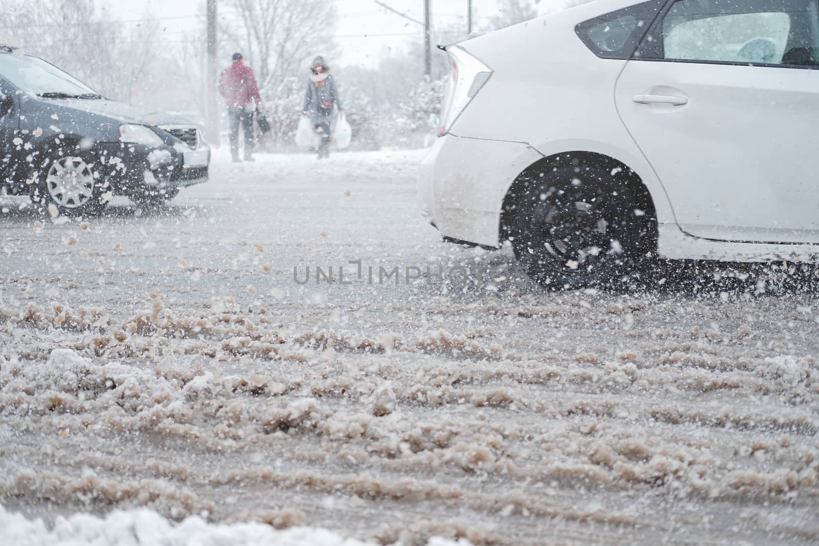 City traffic in snow storm, motion blur. Cars go through messy uncleaned road, concept of road safety in bad weather conditions