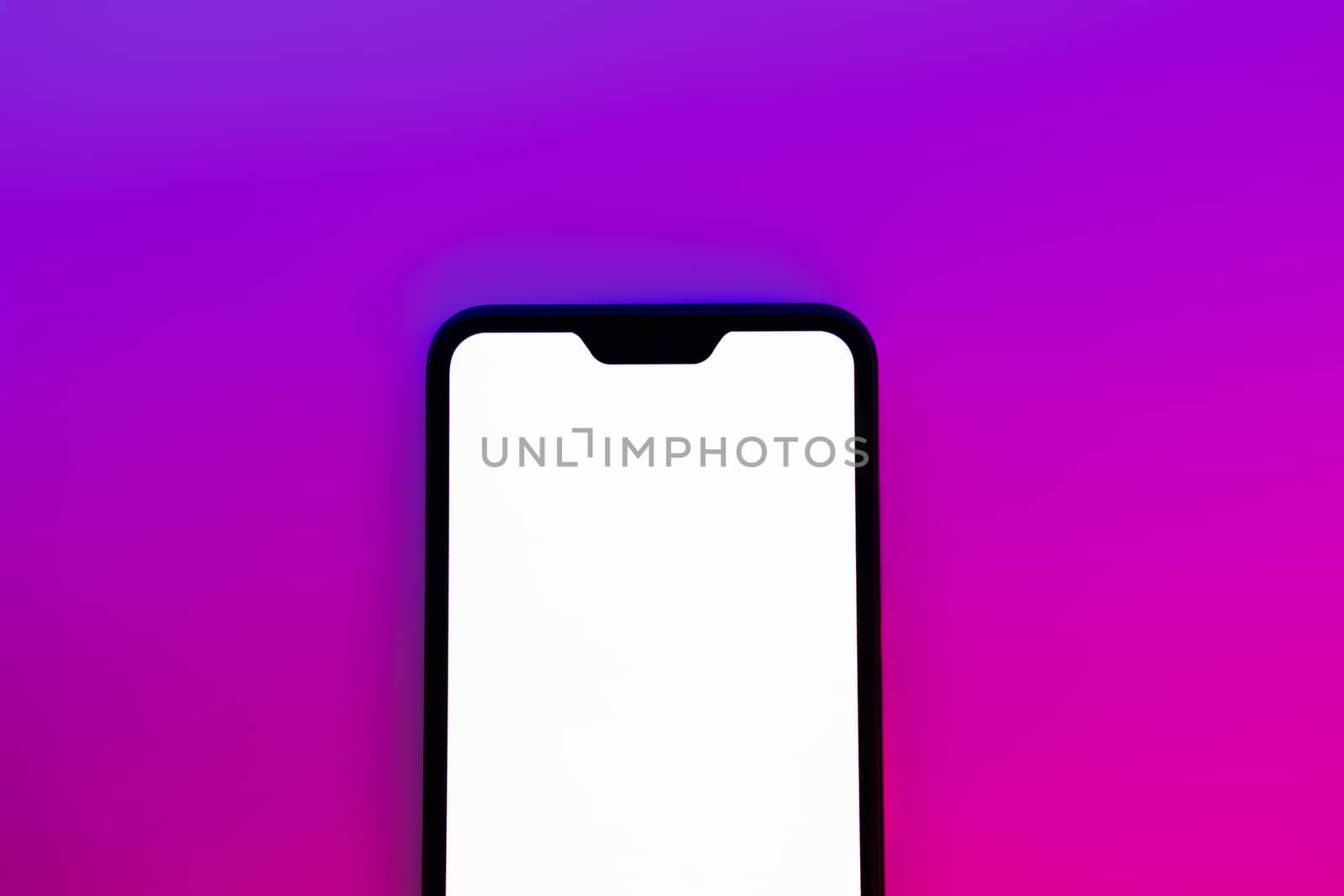 Modern generic smartphone in neon backdrop. by photoboyko