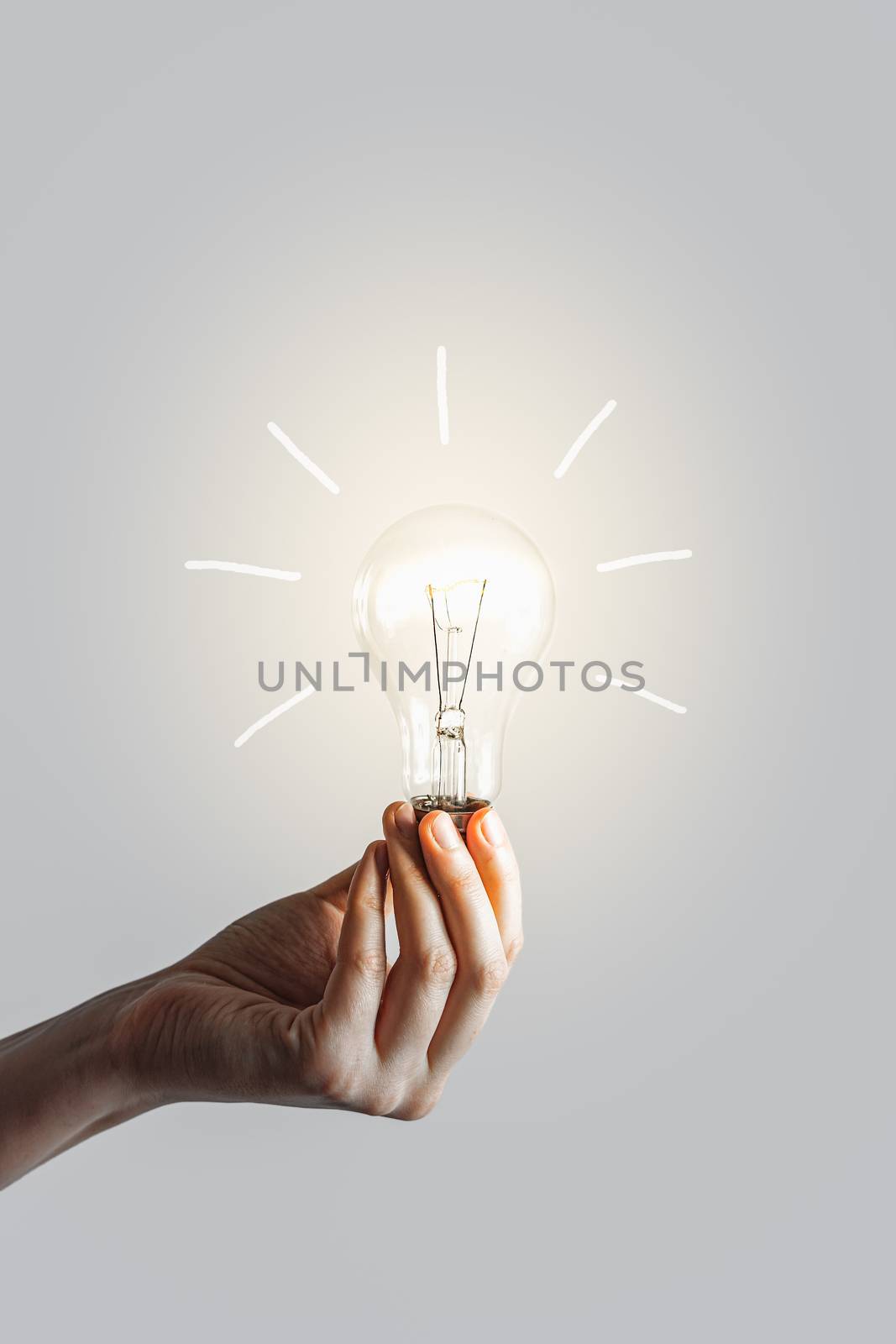 Glowing lightbulb in human hand. by photoboyko