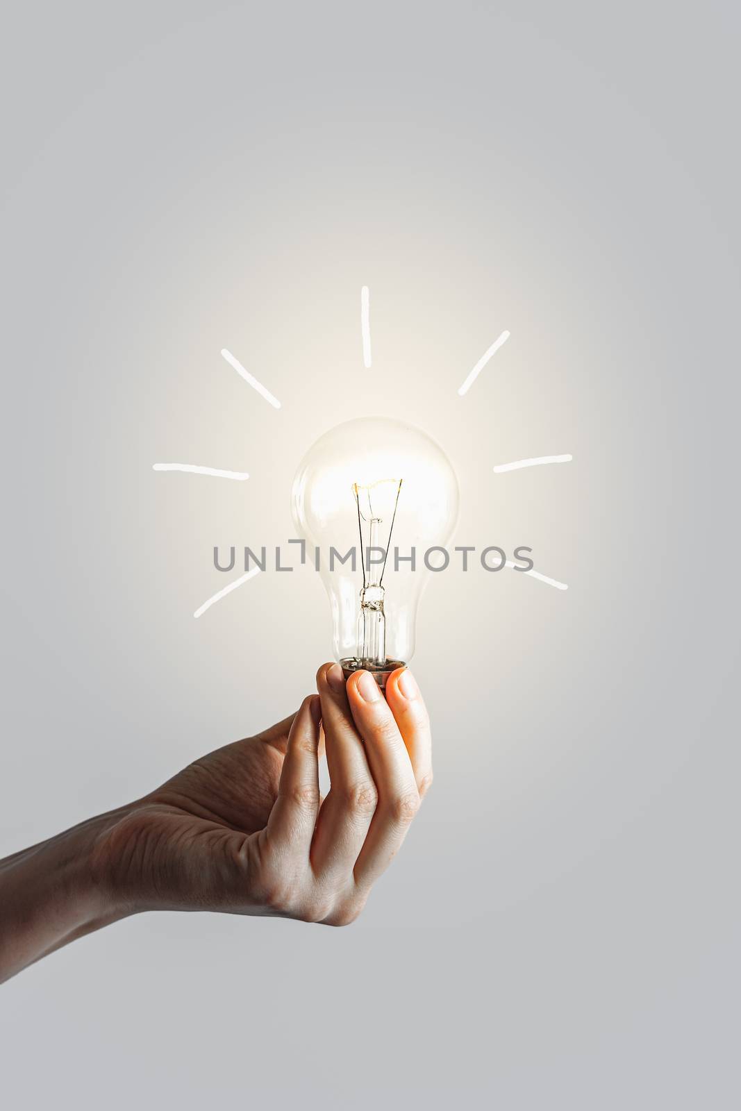 Glowing lightbulb in human hand. Concept of inspiration muse and new ideas creation