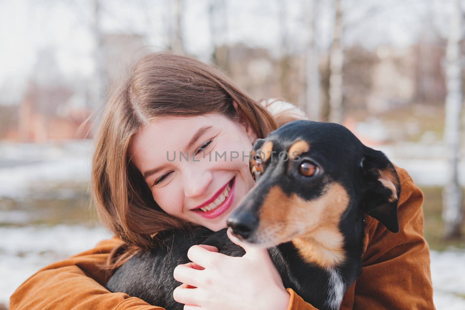 Human being happy with a dog. Loving pets concept: happy young woman hugs her dachshund at a walk