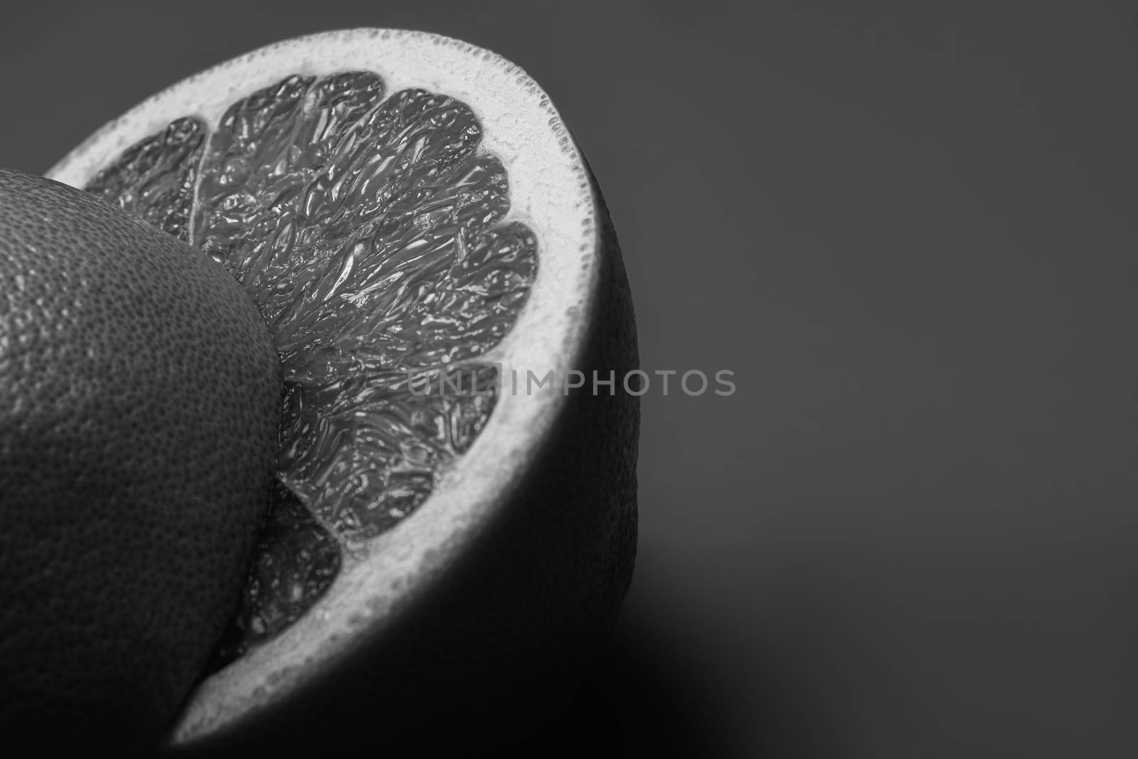 Grapefruit cut in half in dark monochrome backdrop. by photoboyko