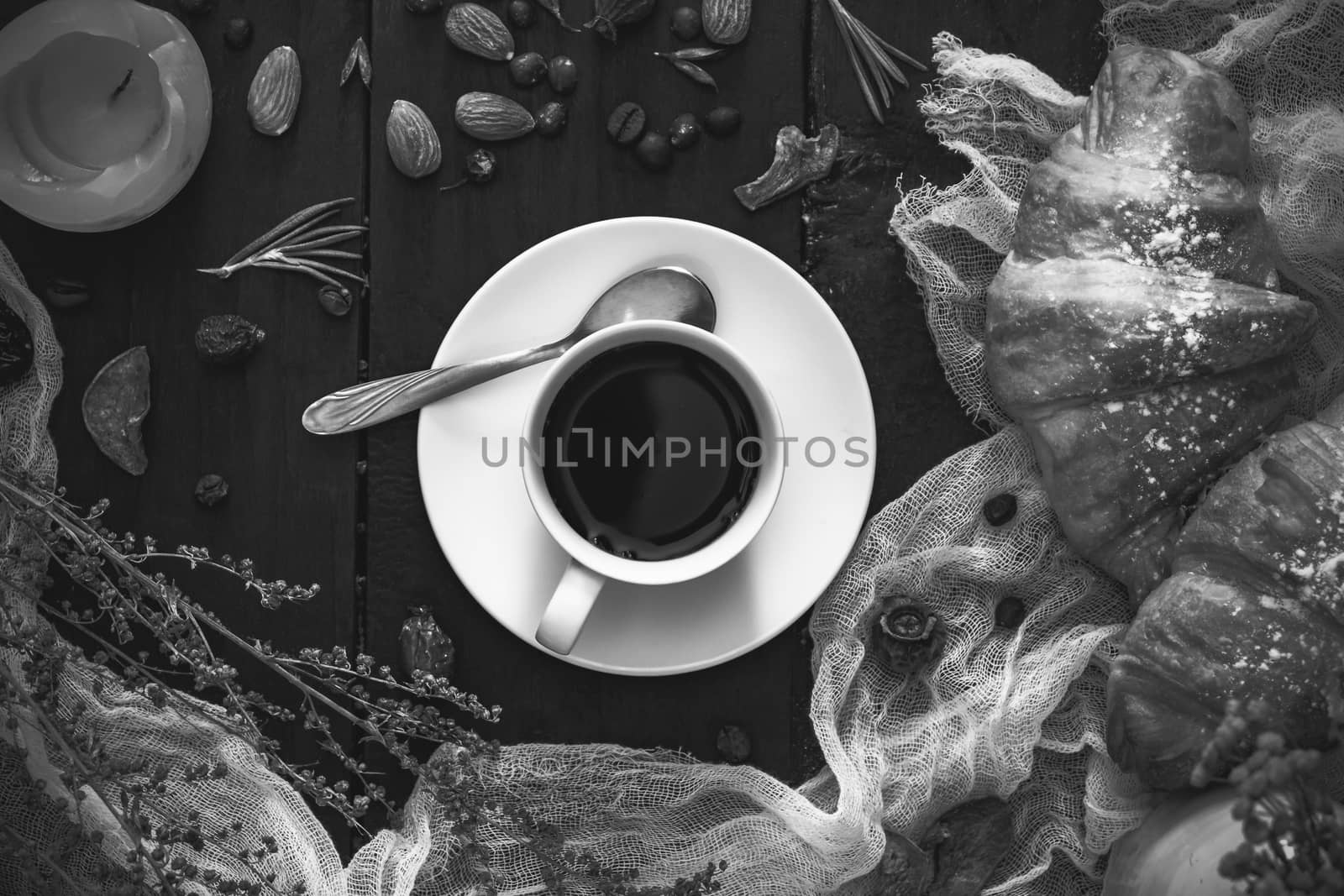 Cup of black coffee and croissants on dark monochrome background by photoboyko