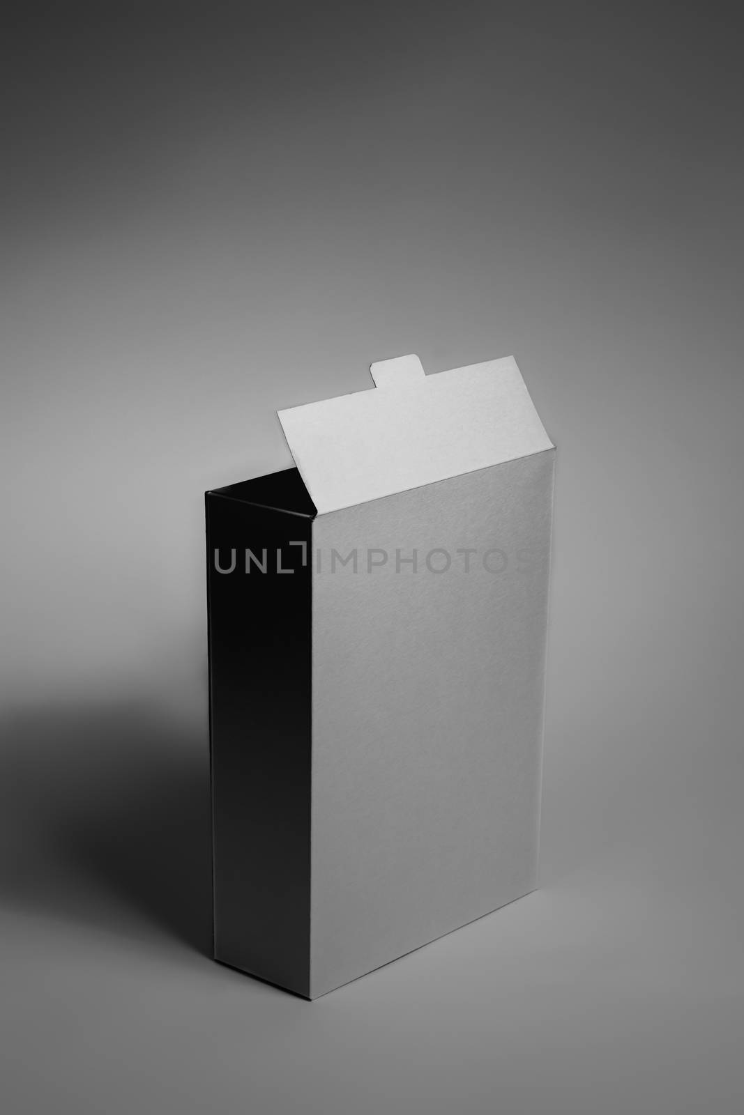 White generic box, studio shot. Blank carton food package, vertical view in low key