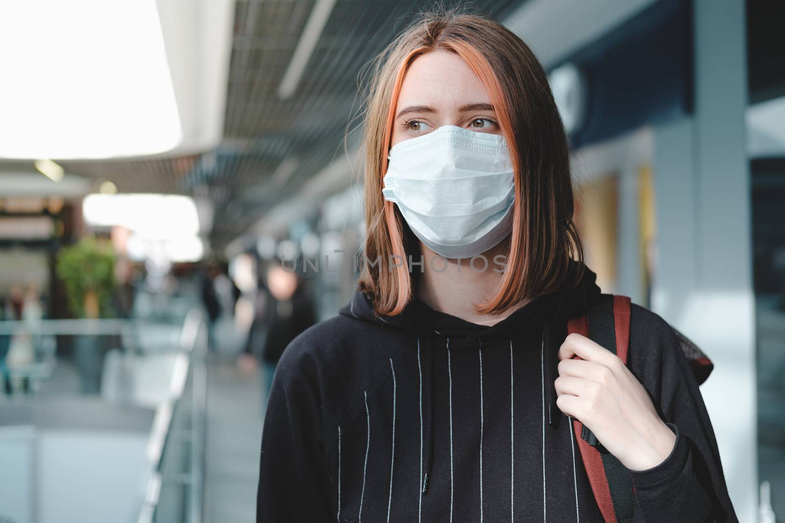 Woman in a protective face mask at public place. by photoboyko