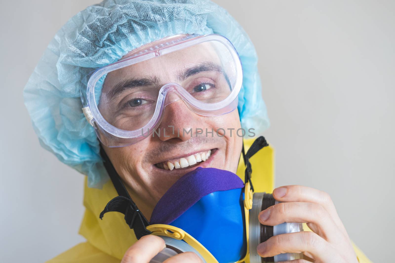 Portrait of a happy medical worker puts off protective gear after a shift. Concept of covid-19 epidemic, healthcare personell and overworking in hospitals