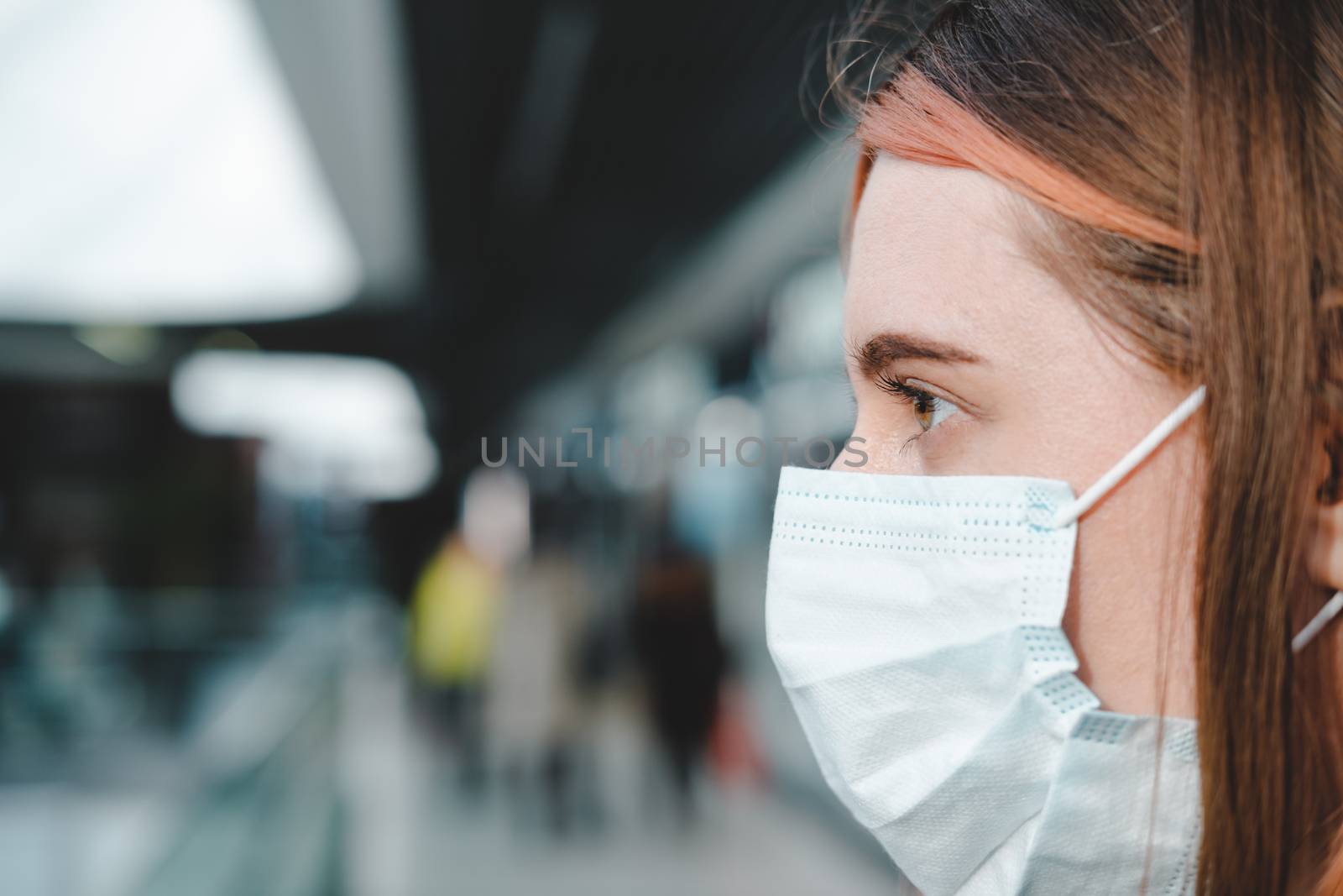 Porrait of a female person with face mask at a public place by photoboyko