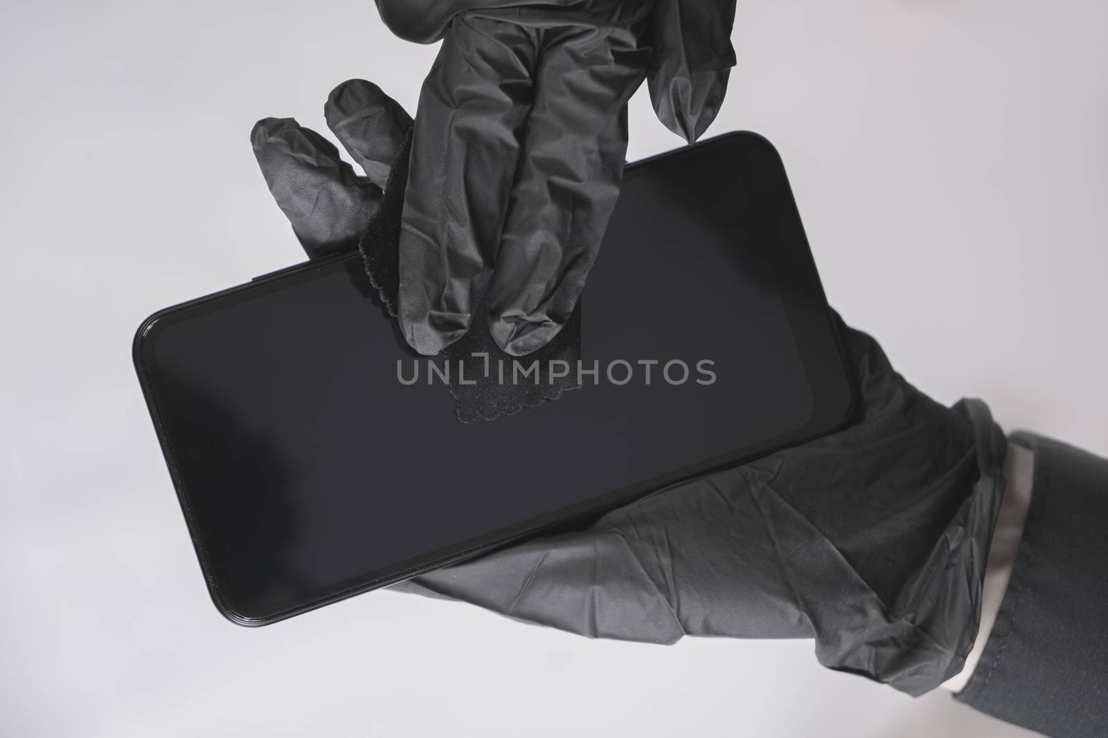 Cleaning the smartphone screen with a wipe. All black concept by photoboyko