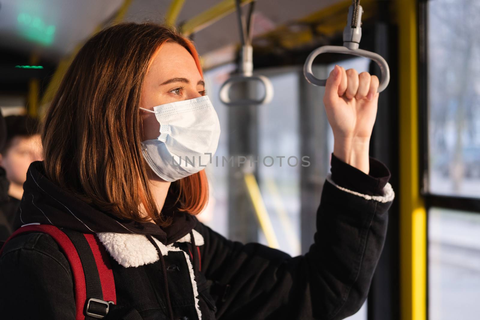 Woman in a protective mask on the train or on the bus. by photoboyko