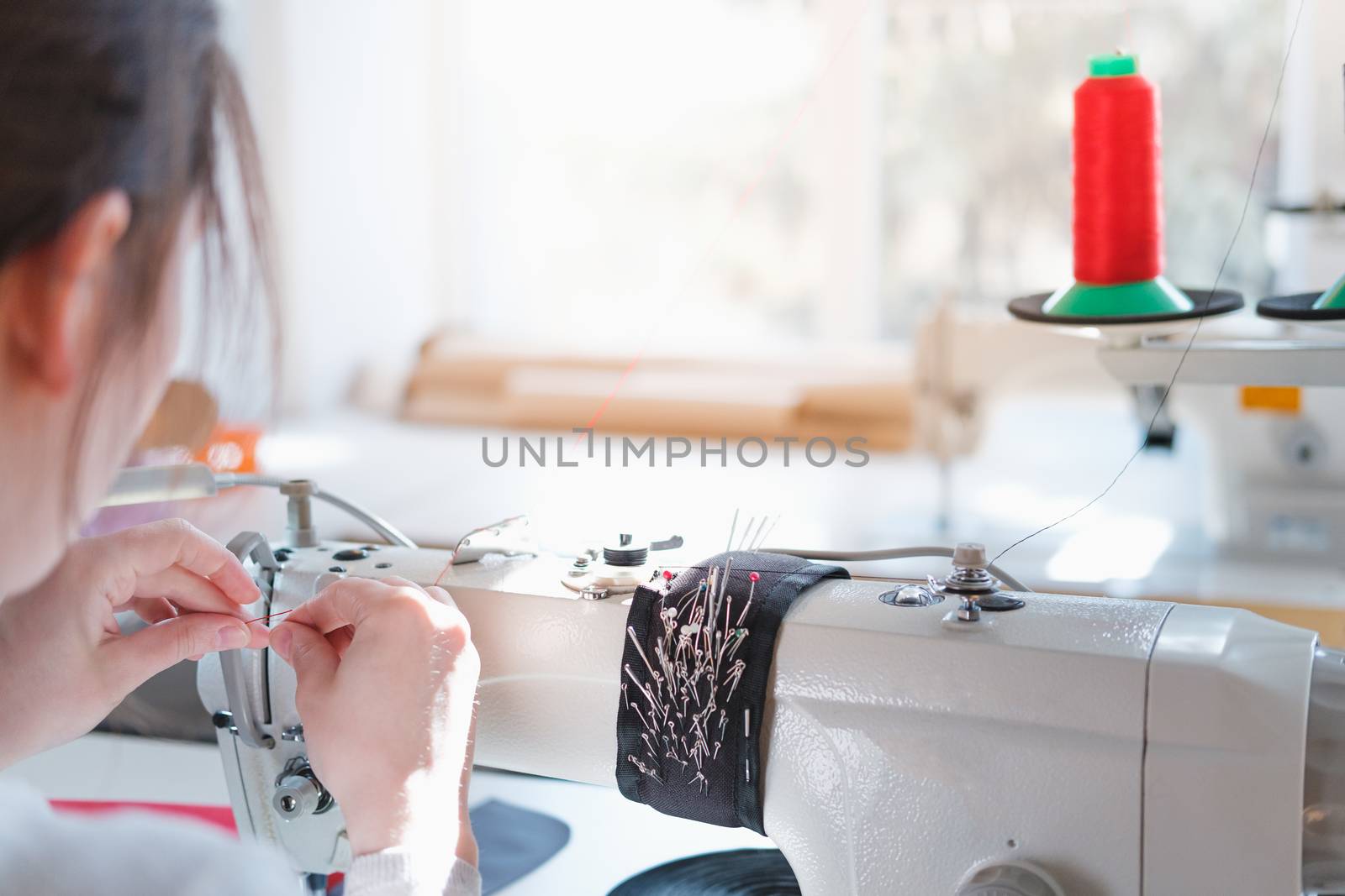 Seamstress at her work place, shoulder view. by photoboyko