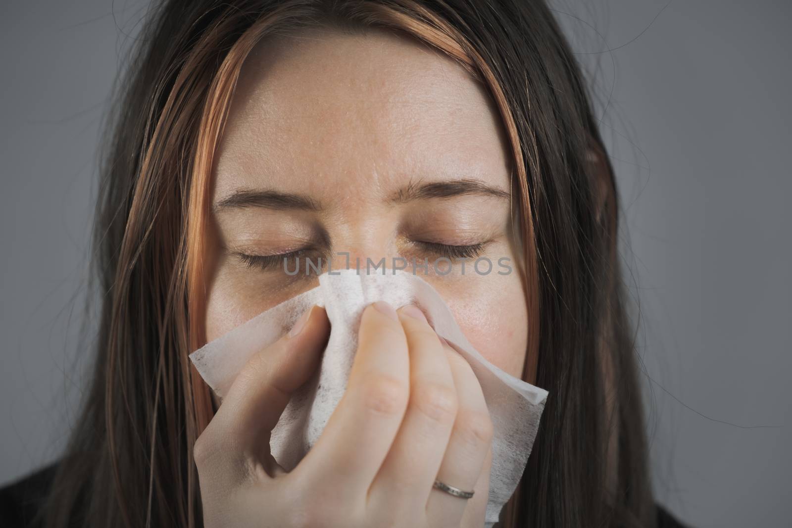 Sneezing, coughing or blowing nose in a single use paper towl. by photoboyko