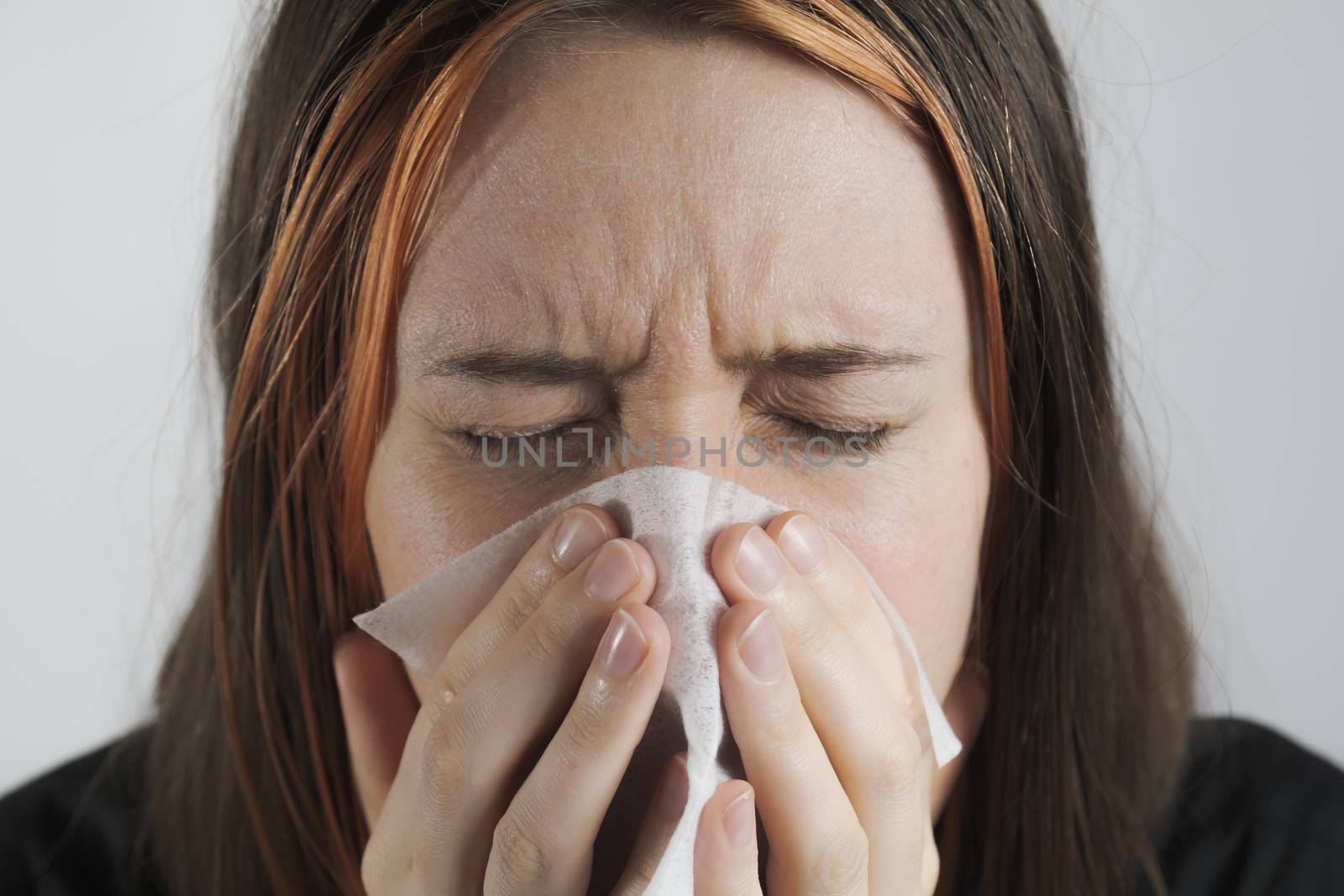 Sneezing, coughing or blowing nose in a single use paper towl. by photoboyko