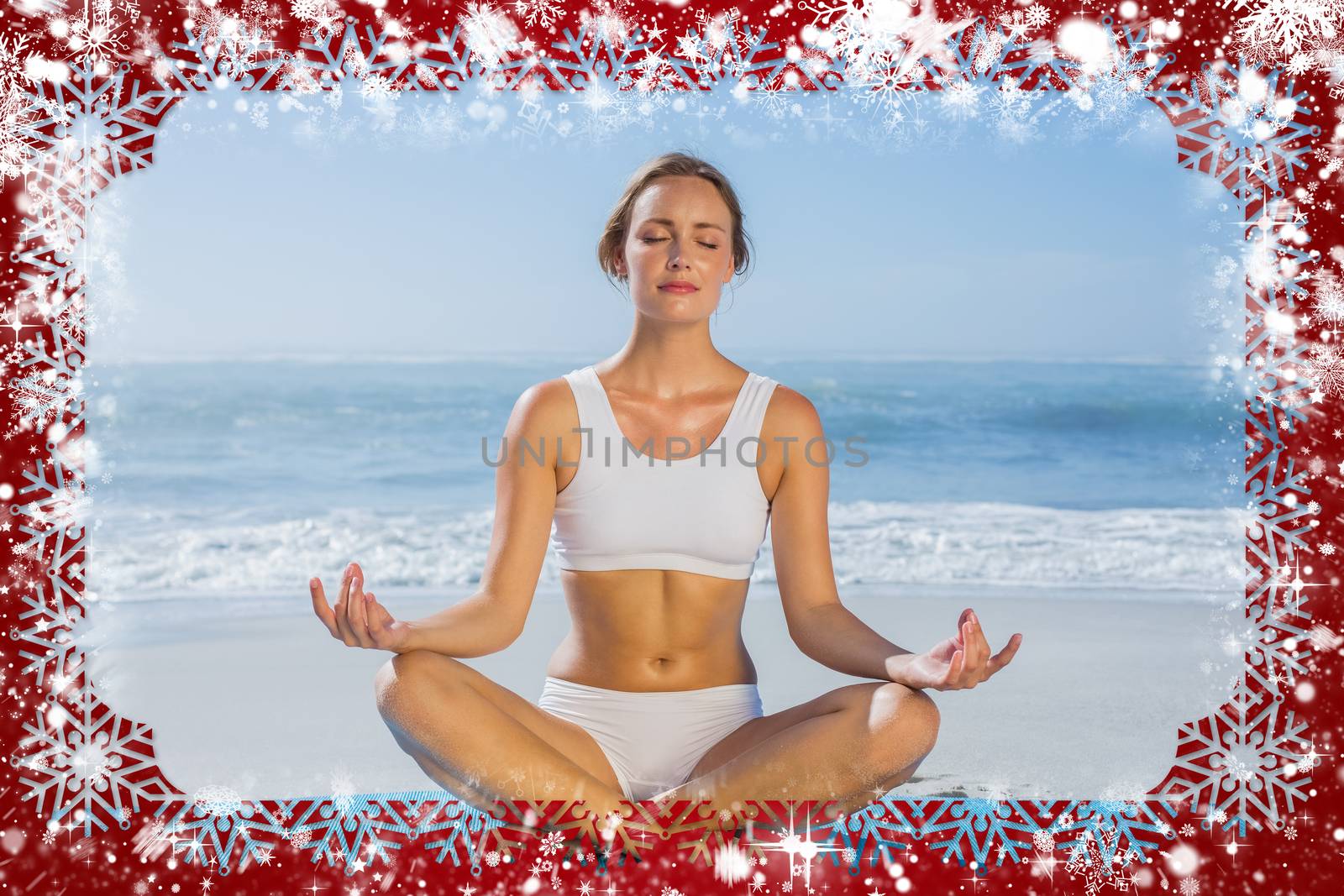 Composite image of fit woman sitting in lotus pose on the beach against snow