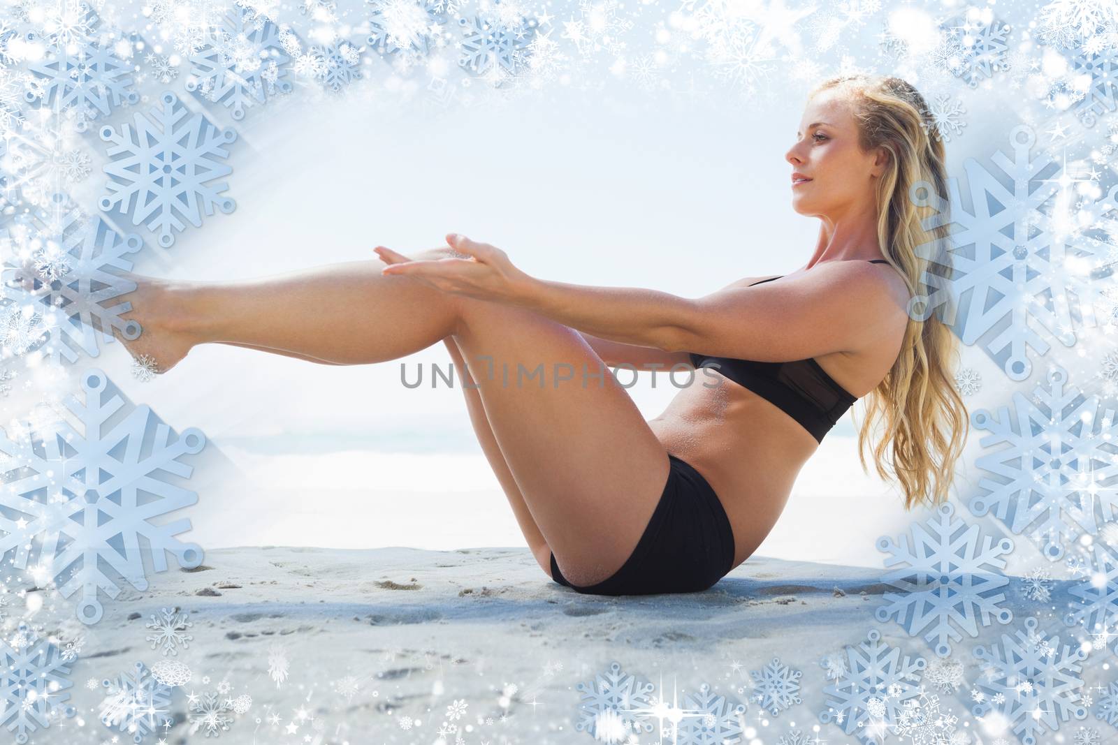 Fit blonde in core balance pilates pose on the beach against snow