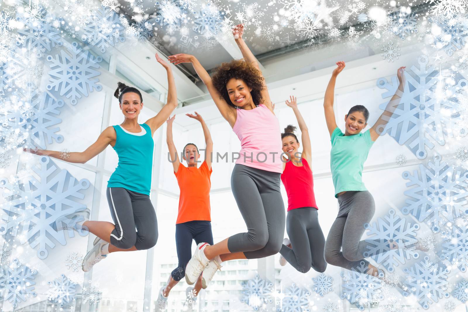 Composite image of snow frame against fitness class and instructor jumping in fitness studio